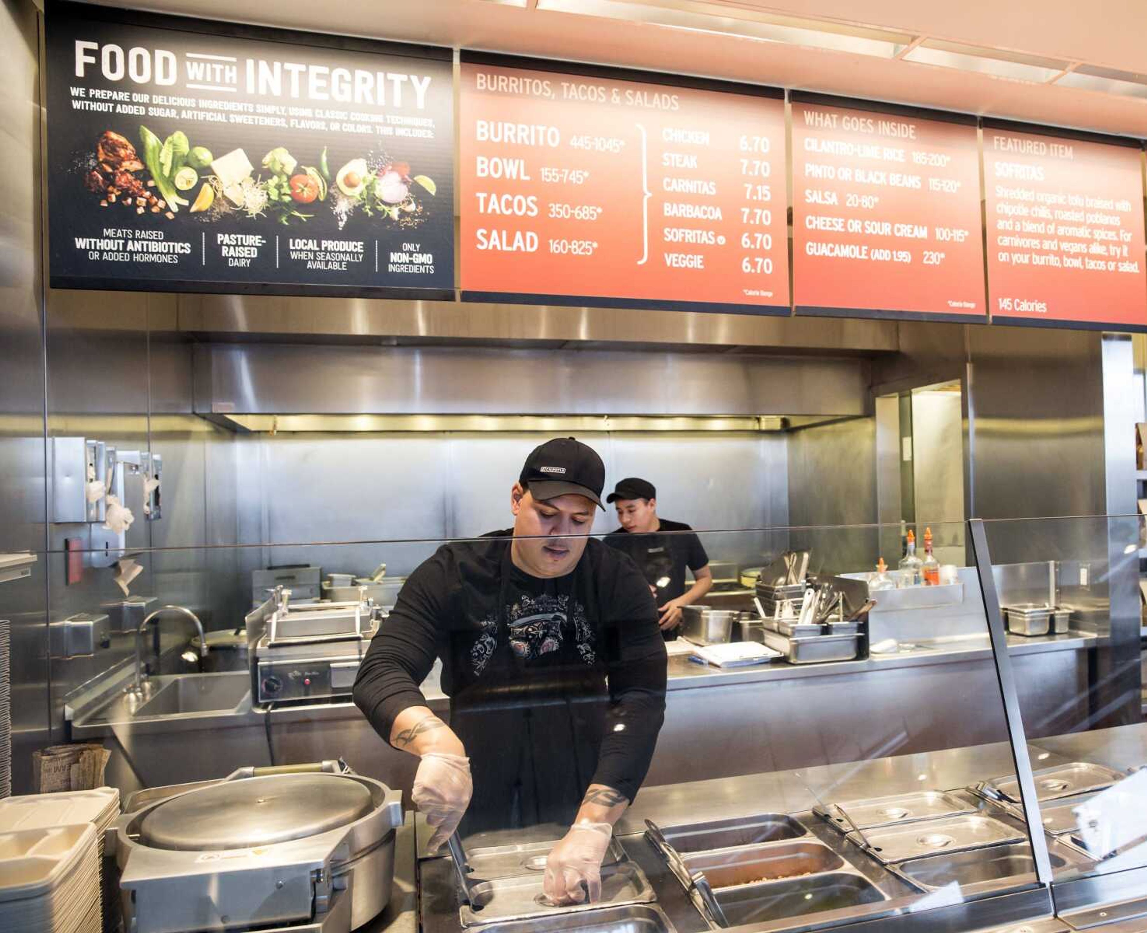 A Chipotle Mexican Grill employee prepares food Dec. 15 in Seattle. After an E. coli outbreak that sickened more than 50 people, Chipotle is changing its cooking to prevent it from happening again. (Stephen Brashear ~ Associated Press)