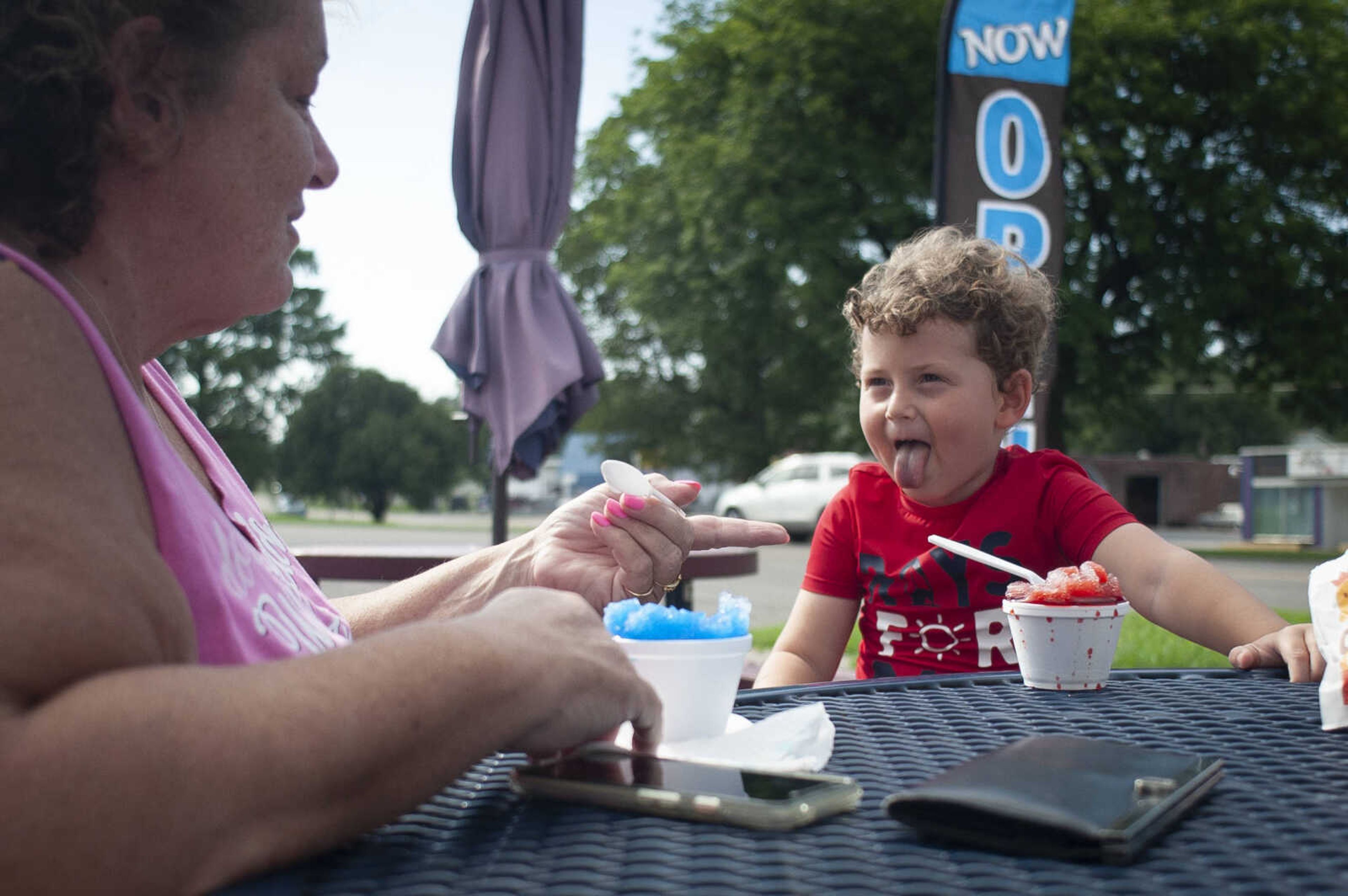 Kael Rains, 4, of Cape Girardeau asks his grandmother Debbie Kays of Cape Girardeau if his tongue is red while eating cherry shaved ice Thursday, July 18, 2019, at Ty's Summer Sno in Cape Girardeau.