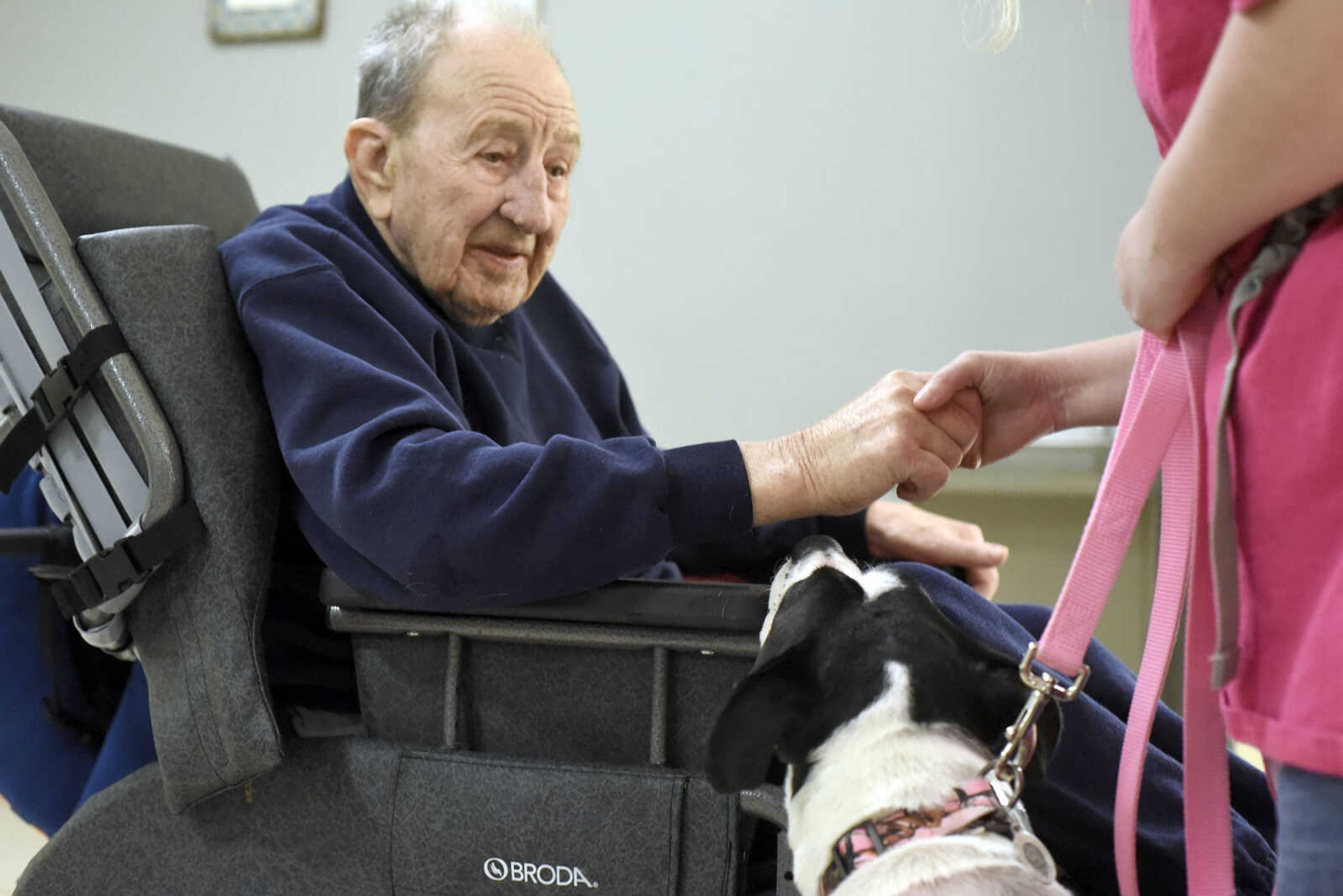 Ed Jaegers holds Jessica Kuehn's hand as she introduces her dog Lovey to him on Tuesday, Feb. 21, 2017, during the Pet Pals visit at the Missouri Veteran's Home in Cape Girardeau.