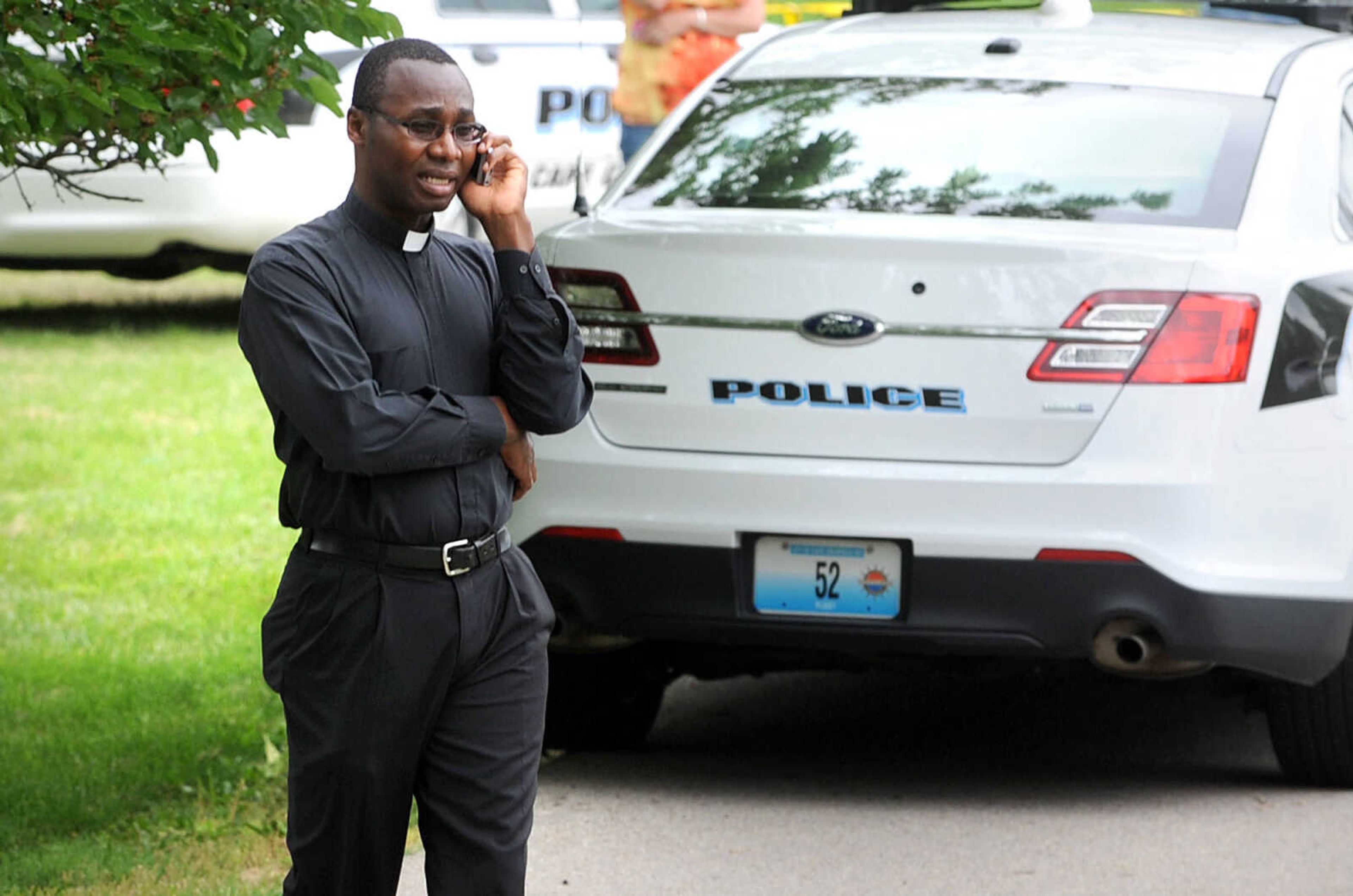 LAURA SIMON ~ lsimon@semissourian.com

Father Patrick Nwokoye takes a phone call outside the scene of a morning shooting at 1220 W. Cape Rock Drive,Thursday, May 30, 2013. Two people, 18-year-old Matthew Joseph and 57-year-old Mary Joseph died from gunshot wounds. George Joseph, 48, is in the hospital for treatment from a gunshot wound.