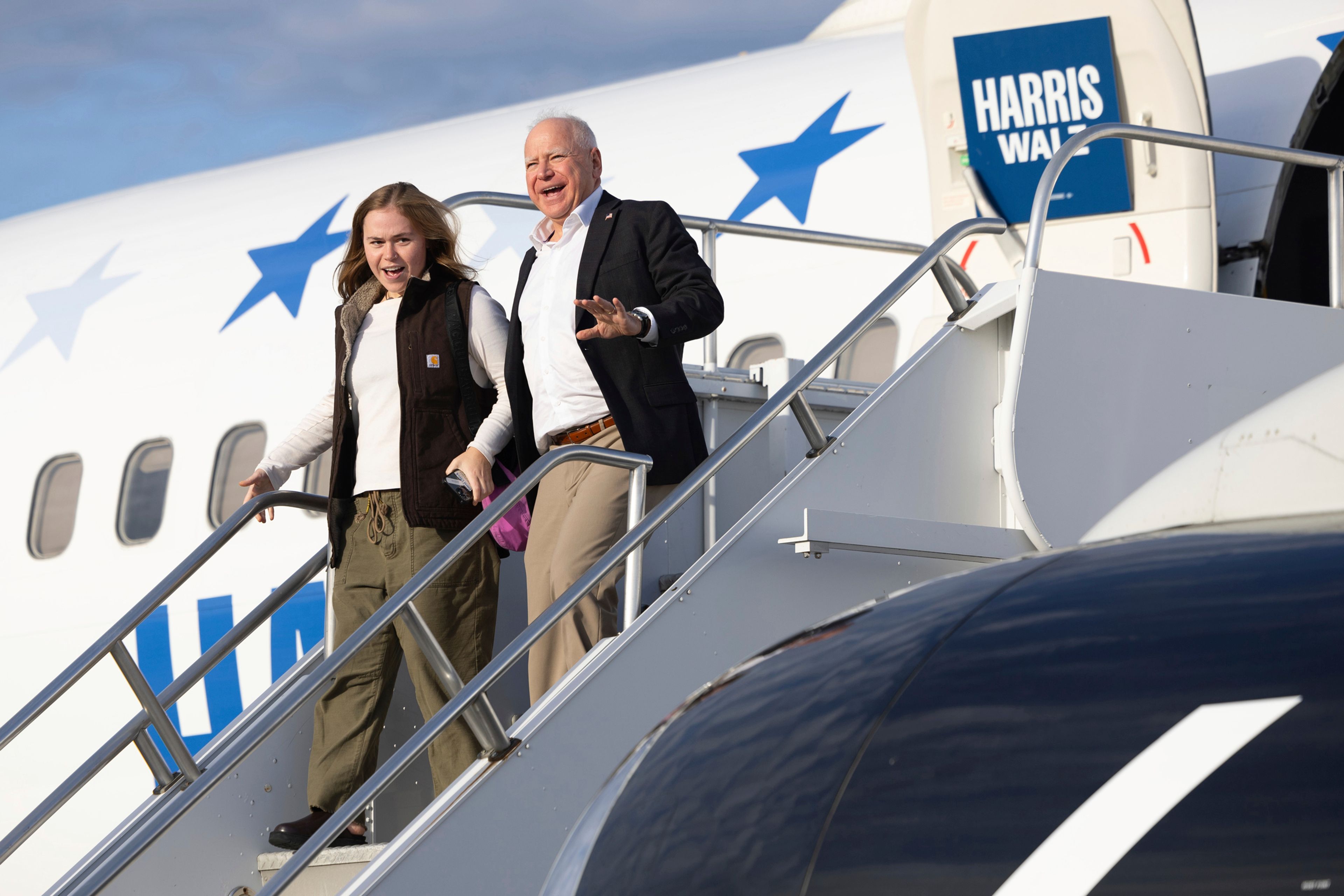 Democratic vice presidential nominee Minnesota Gov. Tim Walz, right, walks off his campaign plane with his daughter, Hope Walz, as they arrives at the Wilkes-Barre/Scranton International Airport in Avoca, Pa., before a campaign event Friday, Oct. 25, 2024. (Christopher Dolan/The Times-Tribune via AP)