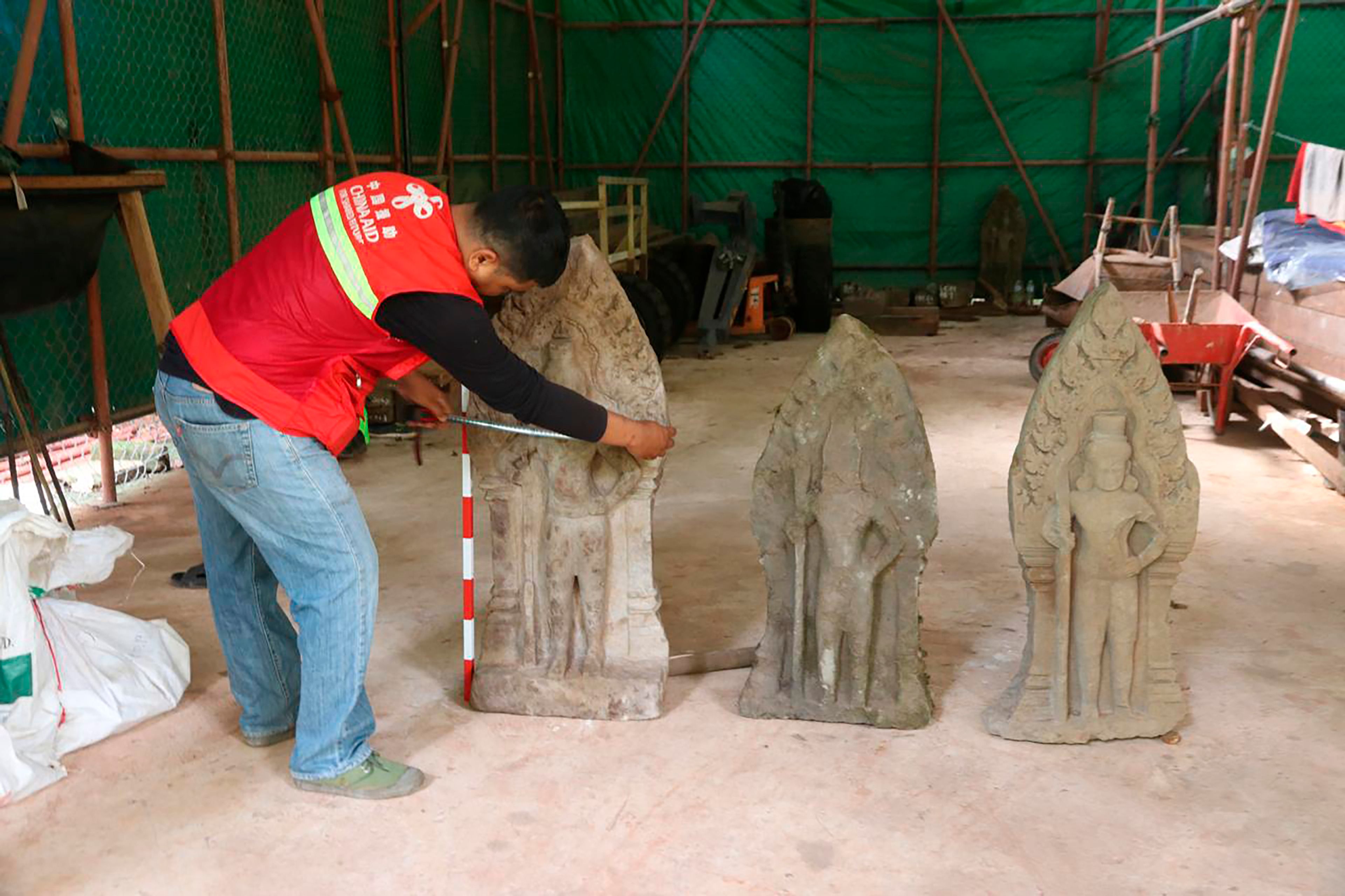 This handout photo provided by Apsaras National Authority shows a centuries-old sandstone statue being measured at Angkor Thom in Cambodia, Oct. 24, 2024. (Phouk Chea/Apsaras National Authority via AP)