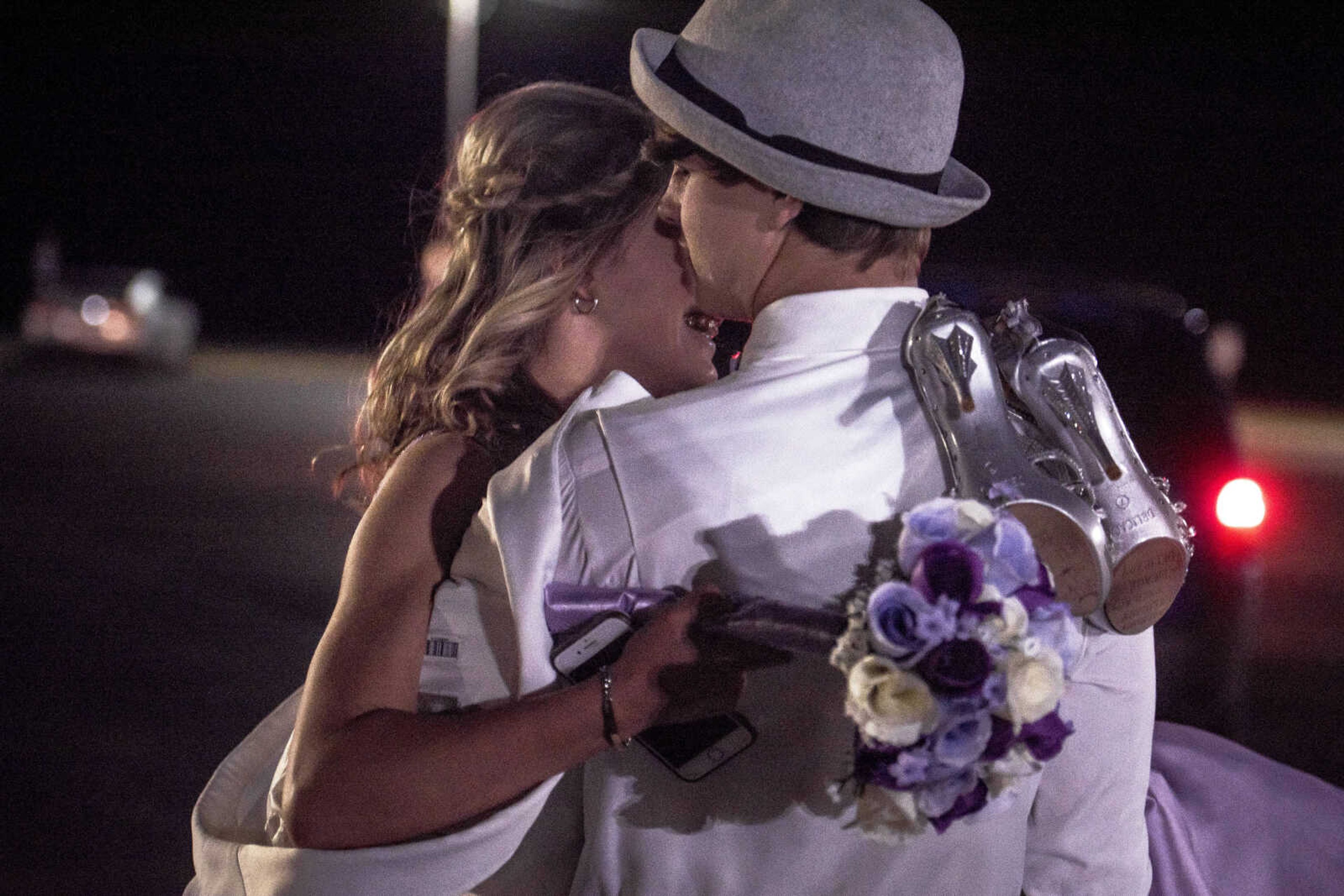 Alex King kisses Karley Childers on the cheek while carrying her across the parking lot as the two left prom Saturday, April 6, 2019, at Kelly High School in Benton.