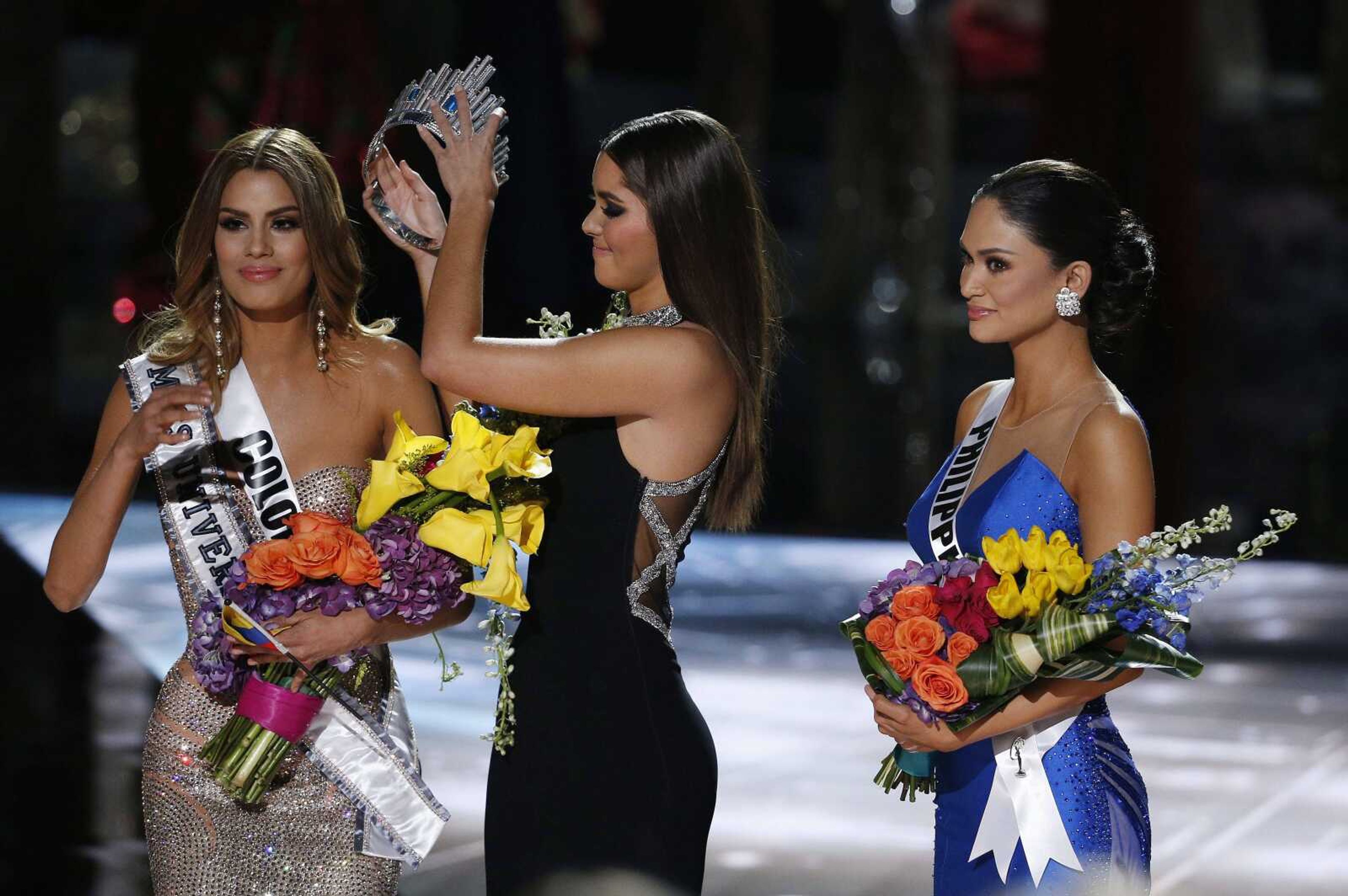 Former Miss Universe Paulina Vega, center, removes the crown from Miss Colombia Ariadna Gutierrez, left, before giving it to Miss Philippines Pia Alonzo Wurtzbach, right, at the Miss Universe pageant on Sunday in Las Vegas. Gutierrez was incorrectly named the winner before Wurtzbach was given the Miss Universe crown. (John Locher ~ Associated Press)