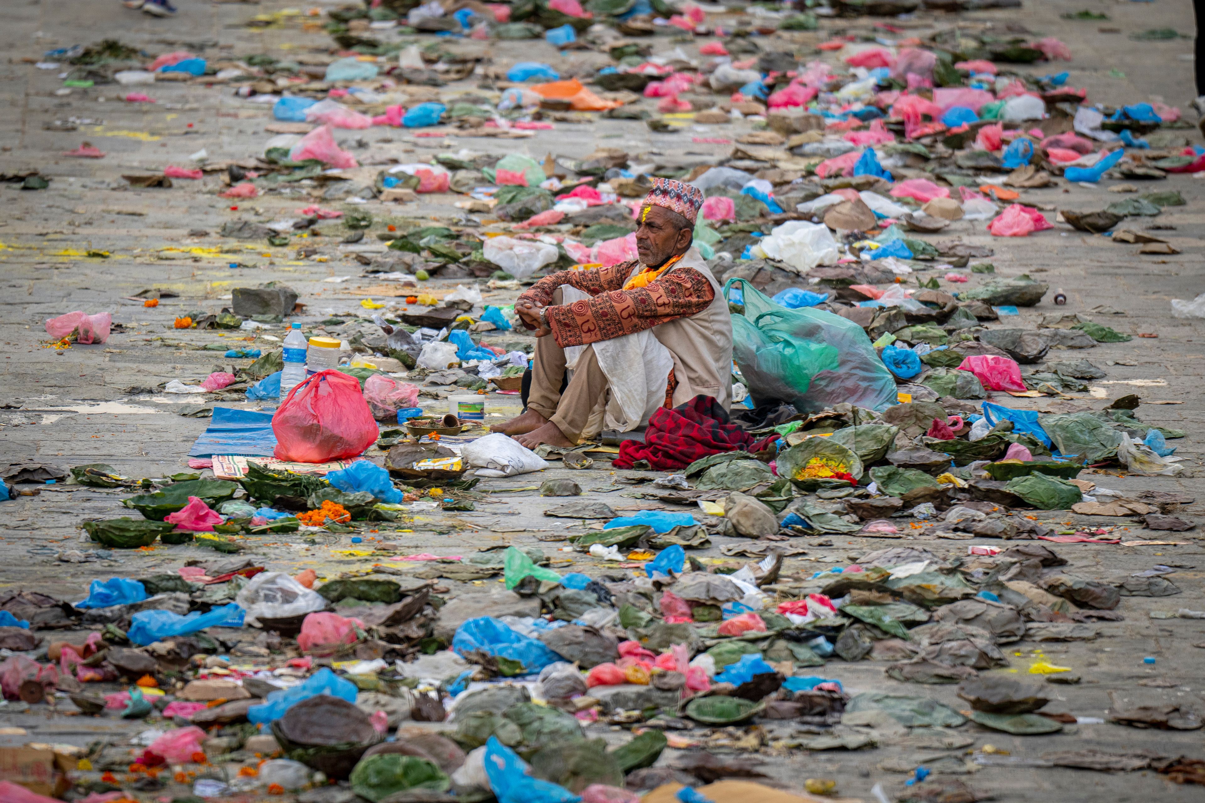 FILE- A priest sits amid the garbage left by devotees during 'Kuse Aunsi' at Gokarneshwor Temple in Kathmandu, Nepal, Monday, Sept. 2, 2024. (AP Photo/Niranjan Shrestha)