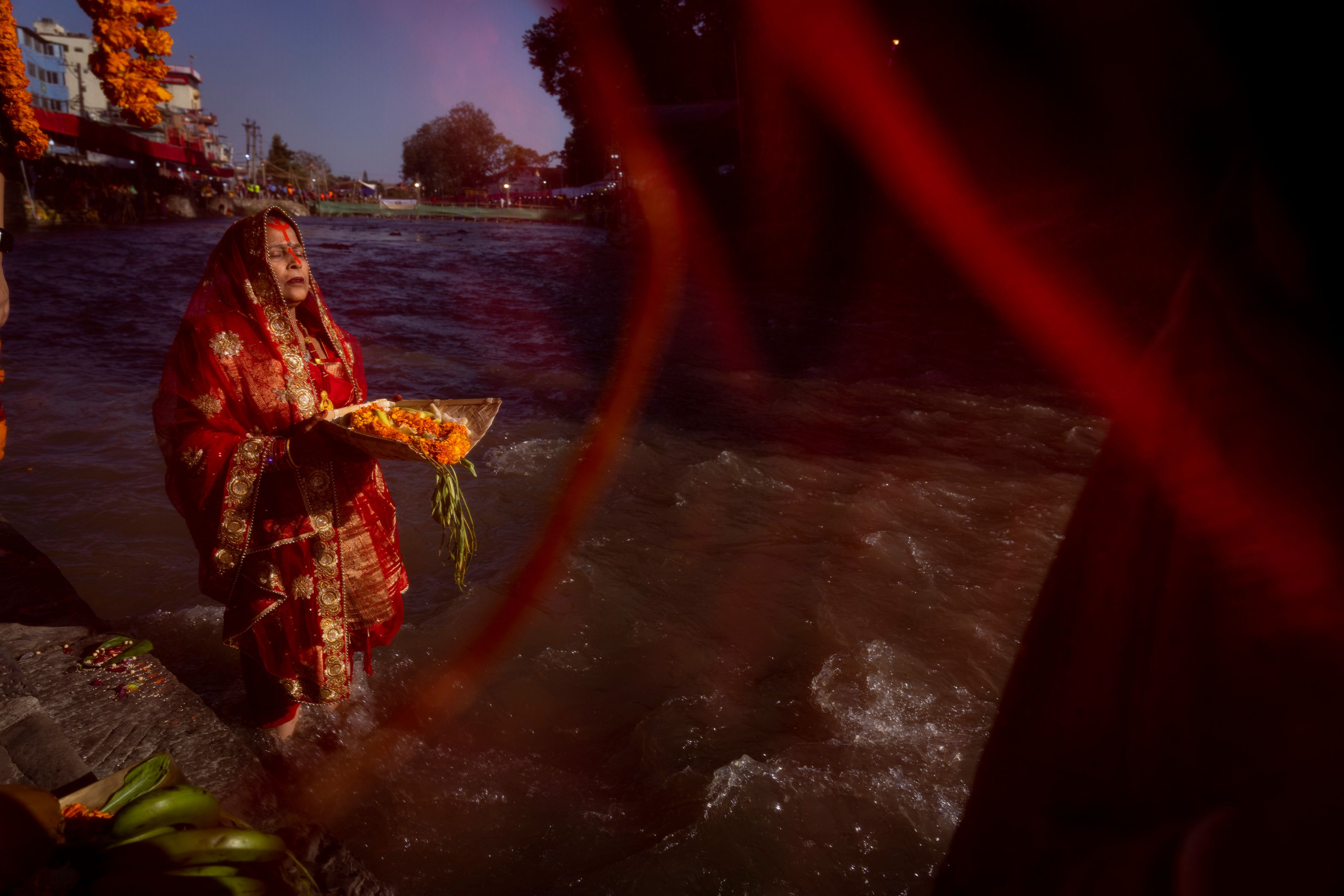 A Nepalese woman offers prayers to the setting sun on the bank of Bagmati River during the Chhath Puja festival in Kathmandu, Nepal, Thursday, Nov. 7, 2024. (AP Photo/Niranjan Shrestha)