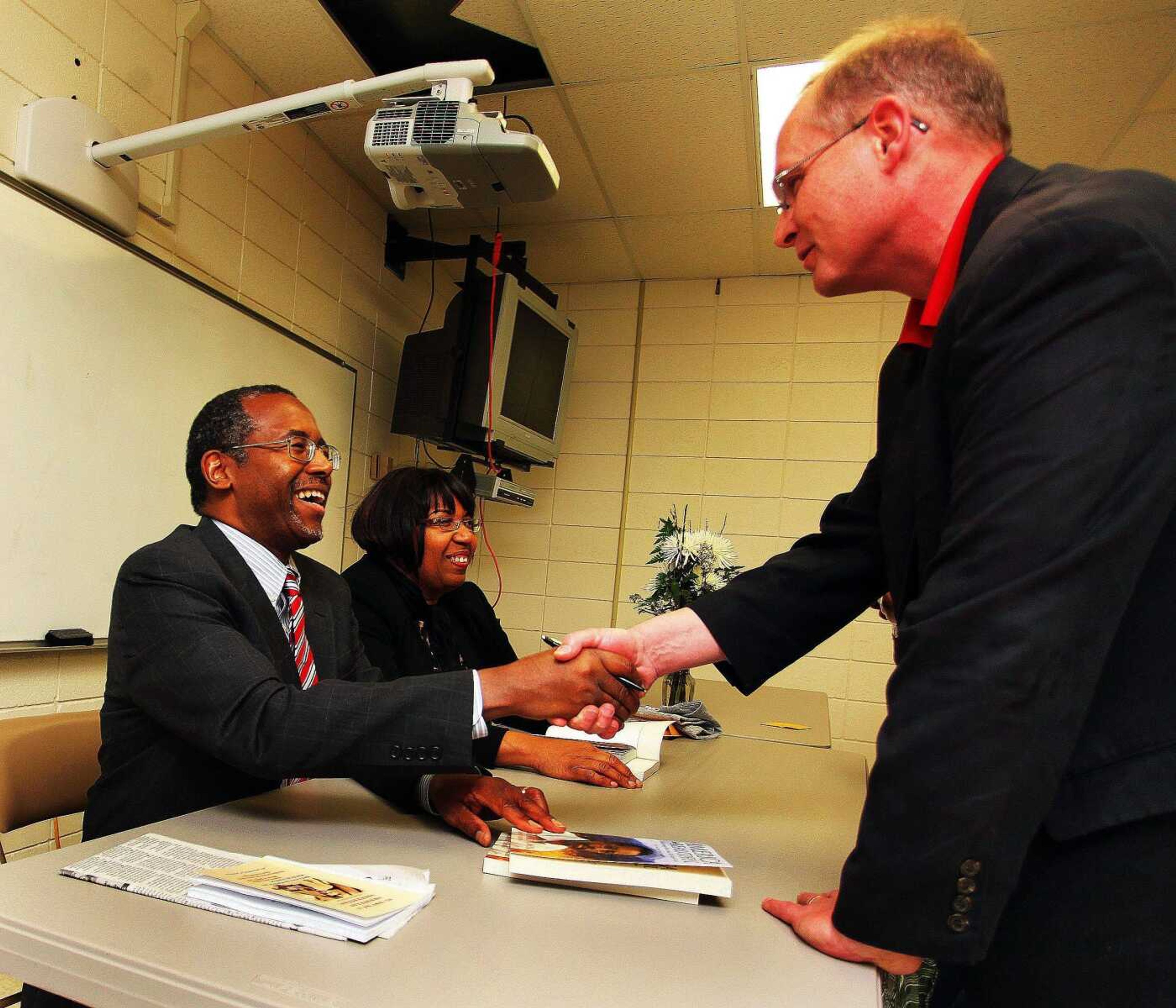 Dr. Ben Carson signs his book "America the Beautiful" for Dave Warren of Sikeston, Mo., after the program in Sikeston on Saturday night. (Bob Greenlee - Standard Democrat)