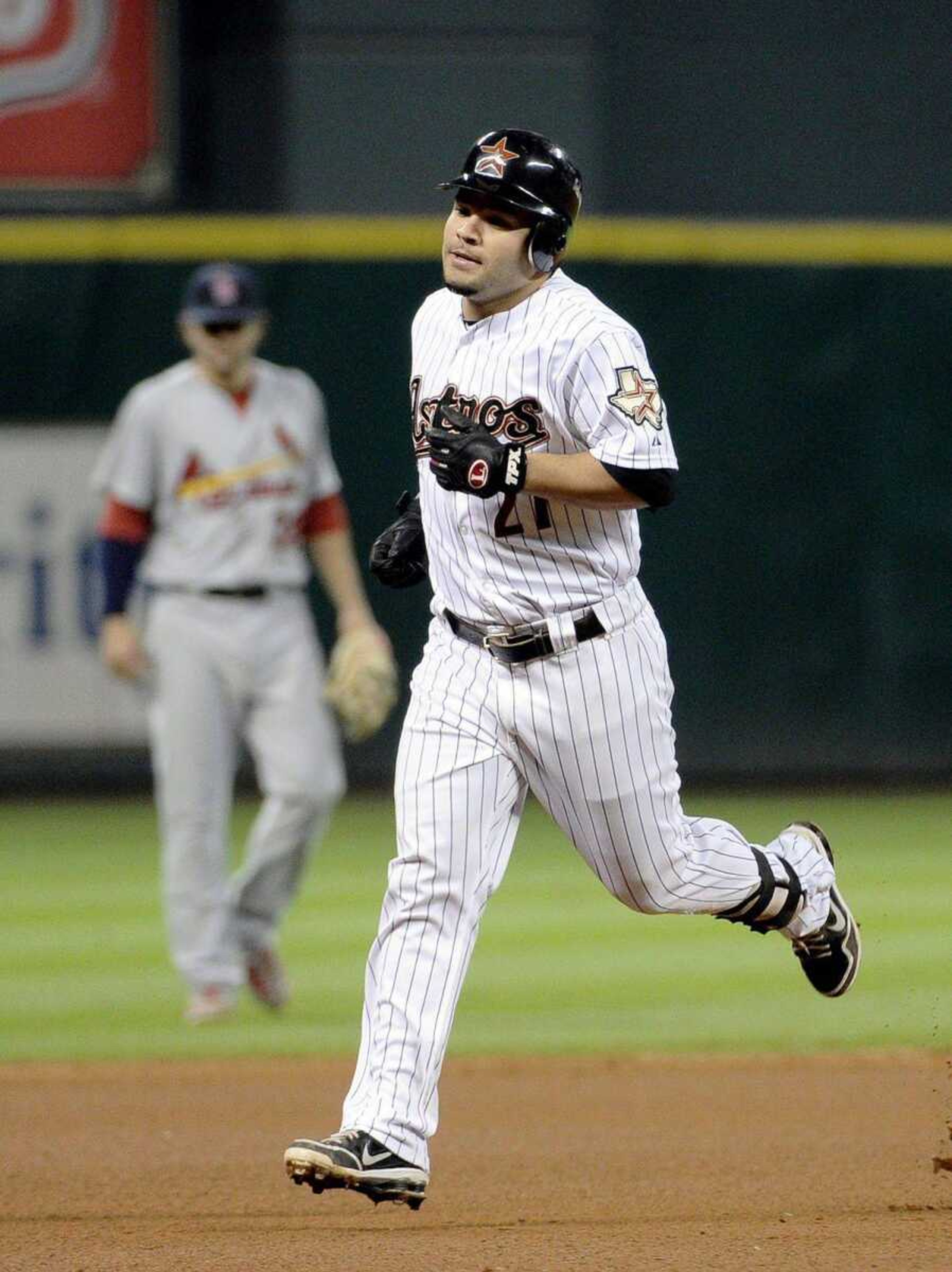 Astros&#8217; Jose Altuve rounds the bases in front of Cardinals shortstop Pete Kozma on a solo homer during the fourth inning Wednesday in Houston. (Pat Sullivan ~ Associated Press)