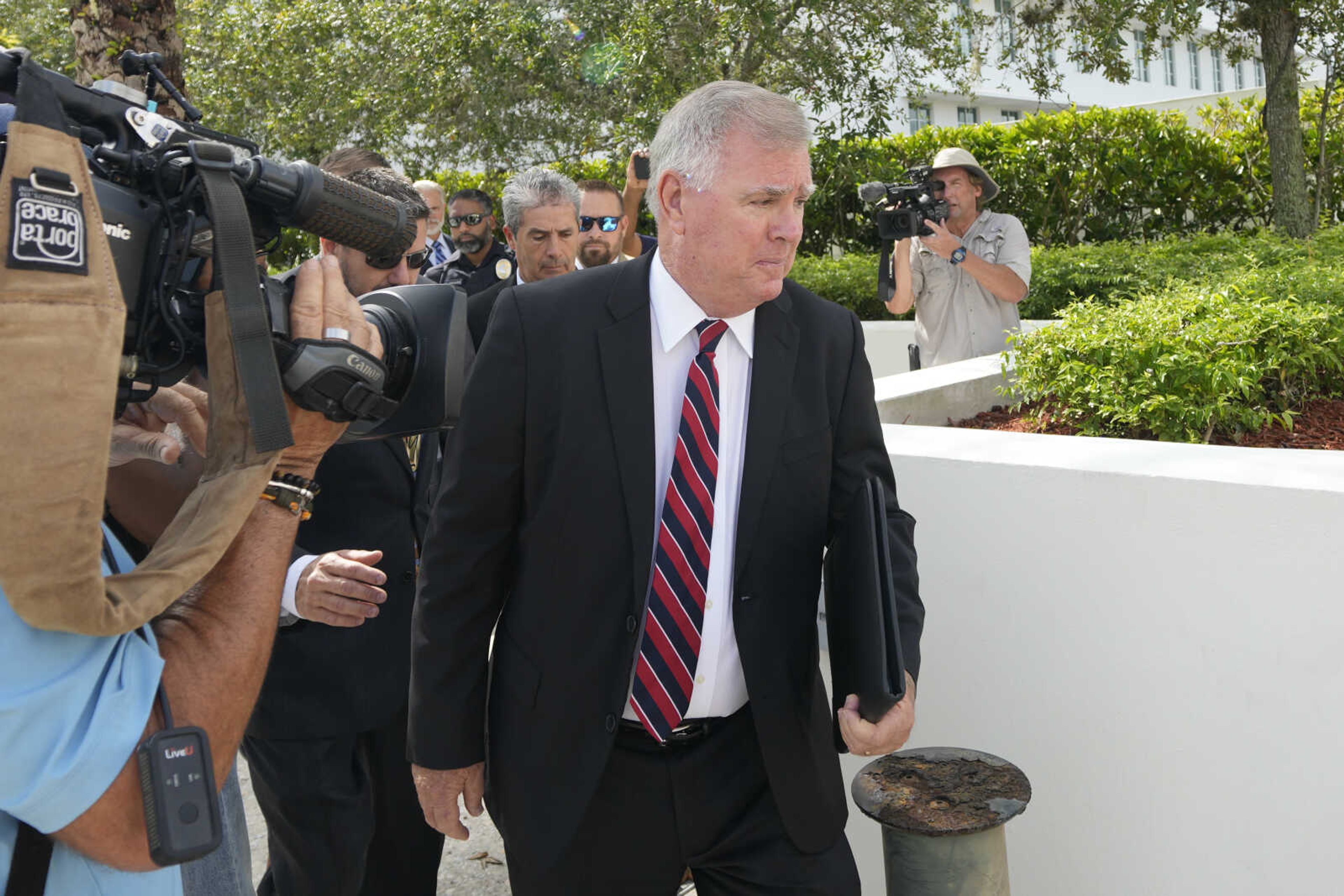 Florida defense attorney Larry Donald  Donnie  Murrell, Jr, center, leaves court trailed by client Carlos De Oliveira, center left, property manager of former President Donald Trump's Mar-a-Lago estate, following an arraignment hearing, Tuesday, Aug. 15, 2023, in Fort Pierce, Fla. (AP Photo/Rebecca Blackwell)