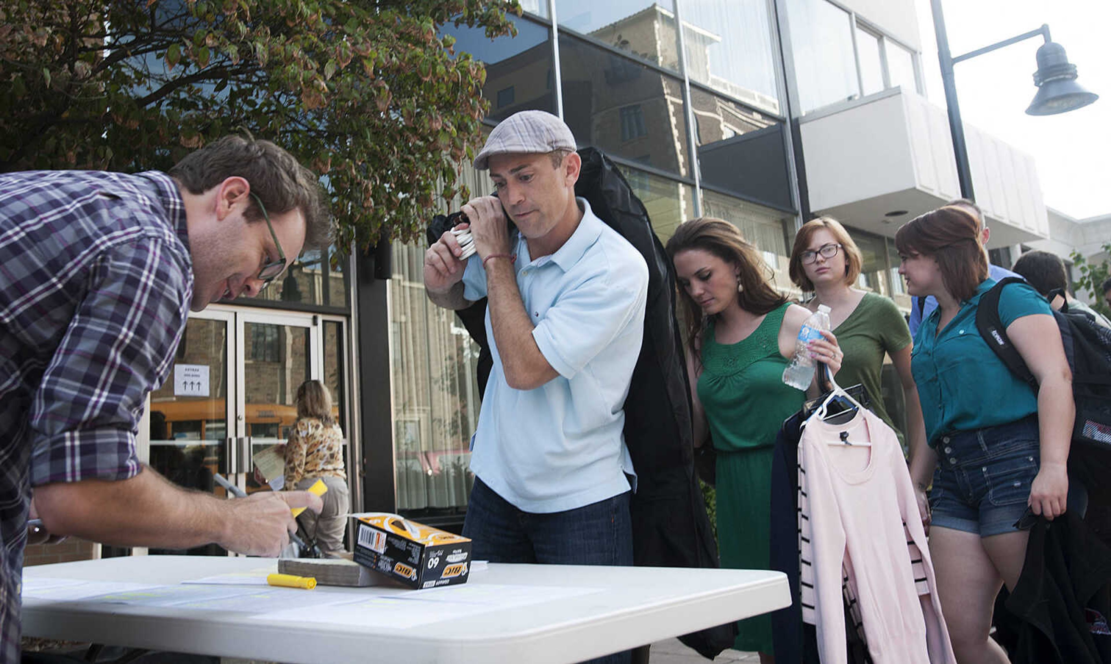 ADAM VOGLER ~ avogler@semissourian.com
Extras working on the 20th Century Fox feature film "Gone Girl," check in before filming a sceneThursday, Oct. 3, in downtown Cape Girardeau.