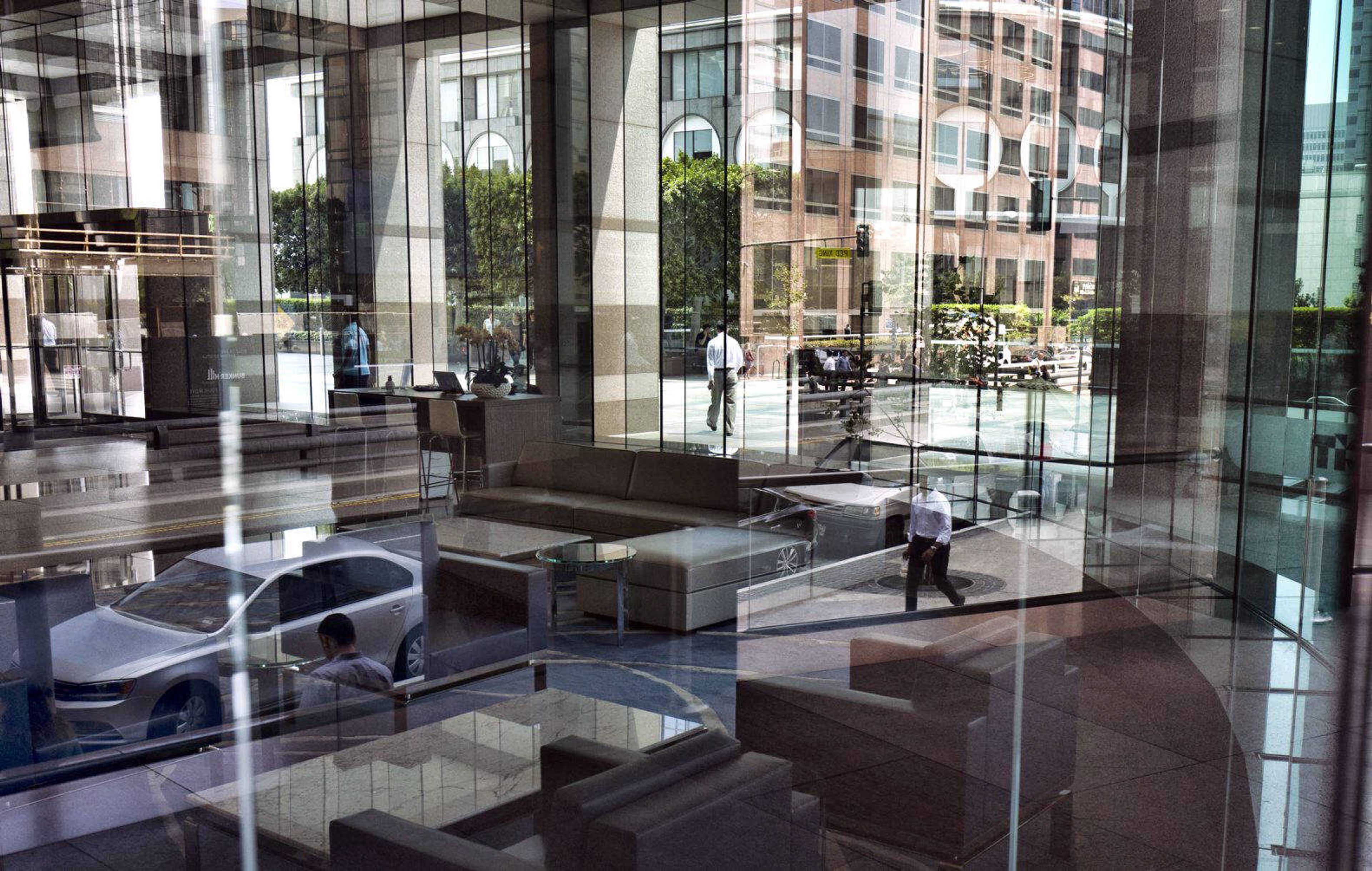 Buildings and officer workers are reflected on windows Aug. 27 in downtown Los Angeles. General Motors' plans to cut more than 8,000 white-collar workers are a warning few jobs are safe. Experts say technology is changing so fast, most workers will have to train for several careers during their lifetimes.