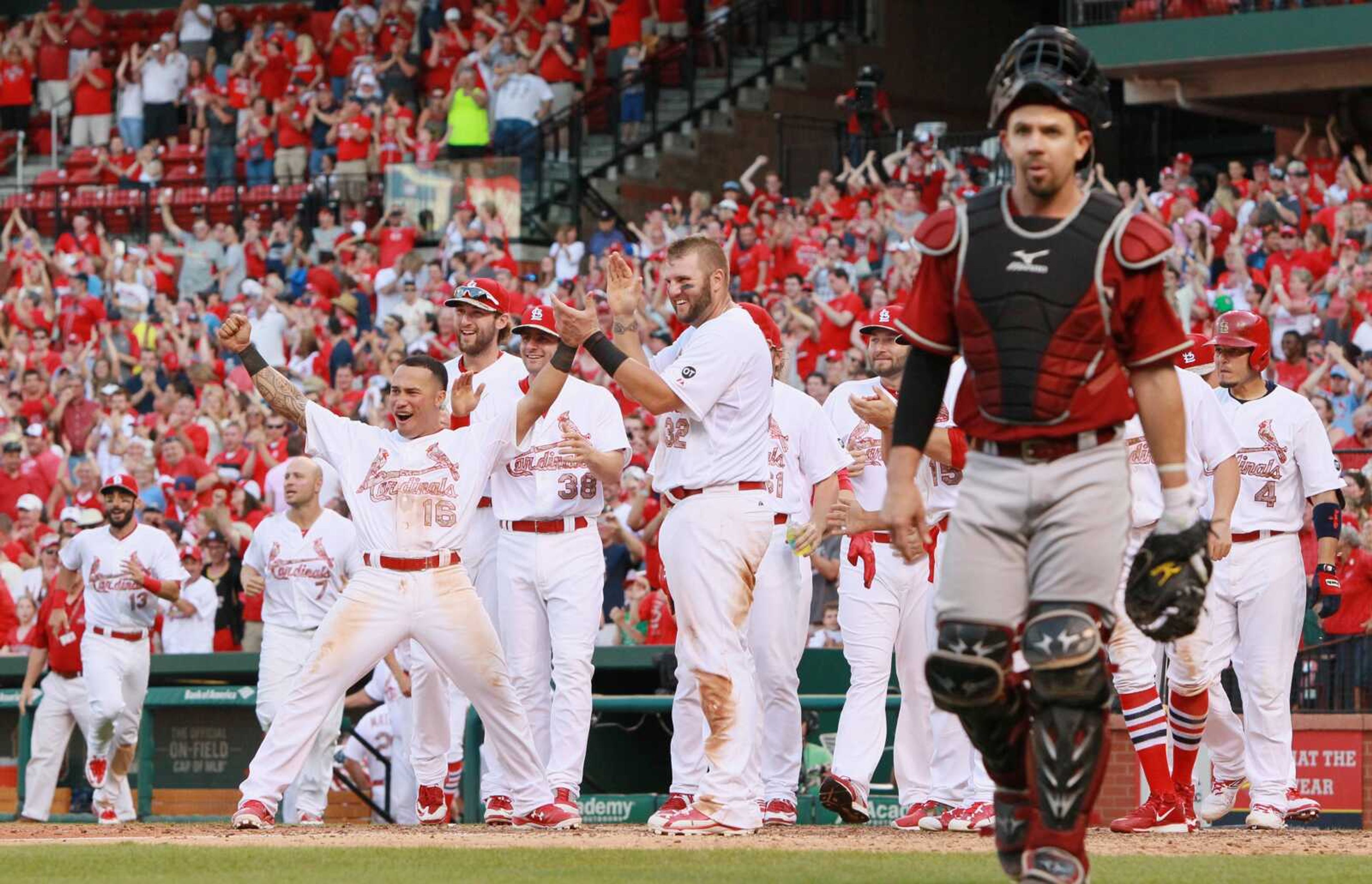 St. Louis Cardinals' Kolten Wong (16) reacts as he waits with teammates to greet Jhonny Peralta after Peralta hit a walk-off home run in the tenth inning during a game between the St. Louis Cardinals and the Arizona Diamondbacks on Monday, May 25, 2015, at Busch Stadium in St. Louis. At right is Diamondbacks catcher Tuffy Gosewisch.  (Chris Lee/St. Louis Post-Dispatch via AP)  EDWARDSVILLE INTELLIGENCER OUT; THE ALTON TELEGRAPH OUT; MANDATORY CREDIT