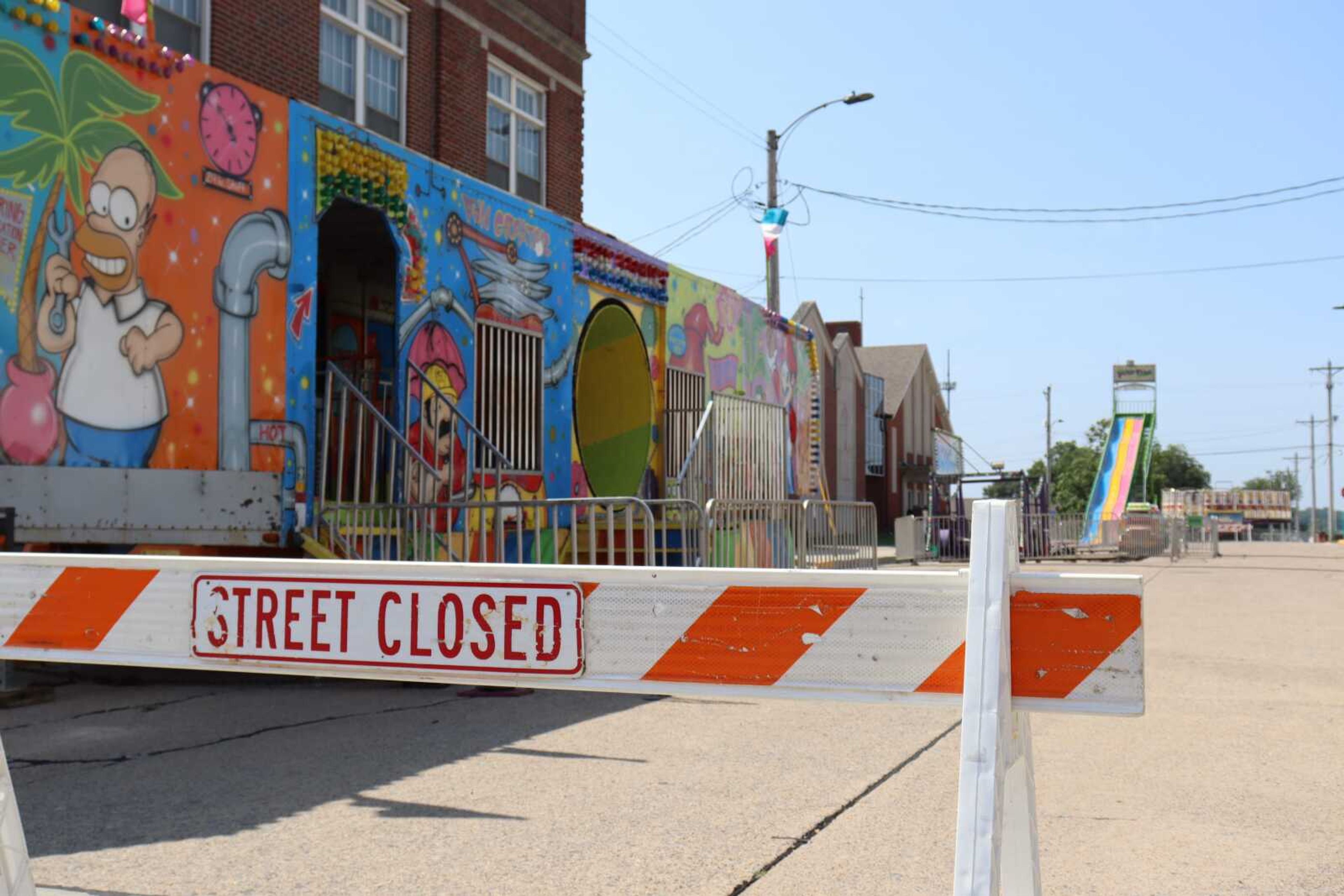 A street closed sign is set up in front of amusement rides on the intersection of South High Street and West Adams Street on Monday, July 24, in Jackson.