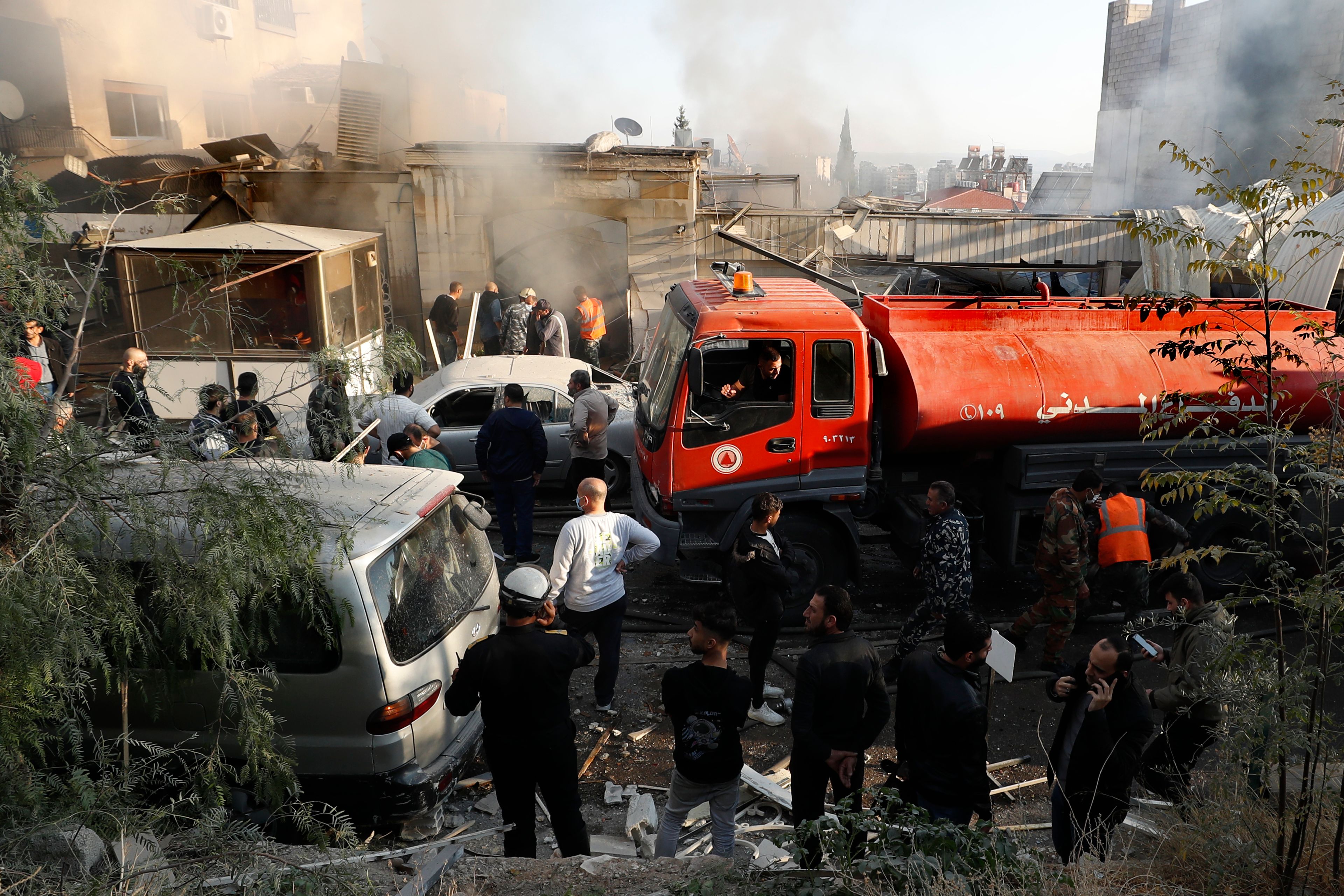 Firefighters and security officers gather at a destroyed building hit in an Israeli airstrike in Damascus, Syria, Thursday, Nov. 14, 2024. (AP Photo/Omar Sanadiki)