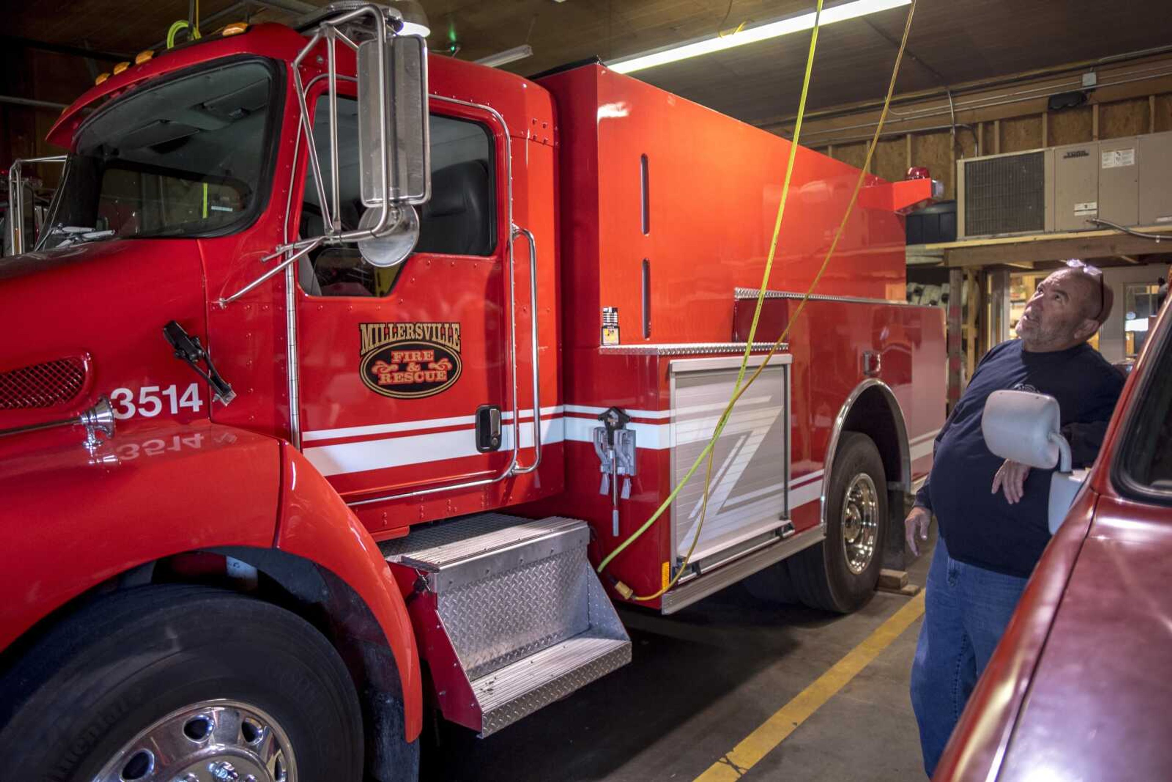 Millersville Rural Fire Protection District chief Ray Warner is seen near one of the district's large firetrucks Tuesday at the Millersville fire station in Millersville.