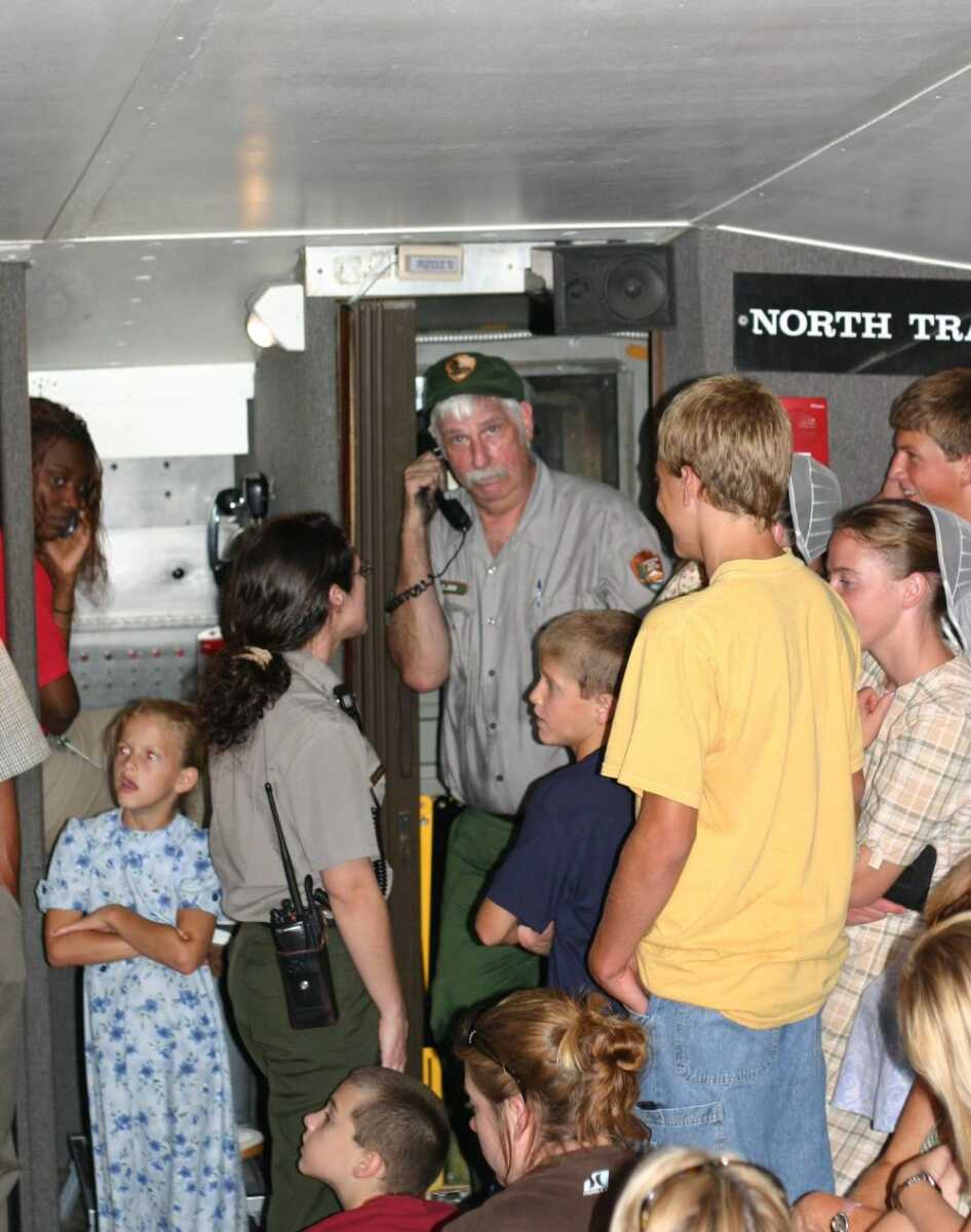 In this photo provided by Eli Lawson, an unidentified National Park Service member talked on a phone Saturday while surrounded with tourists at the top of the Gateway Arch in St. Louis. The Arch's deputy superintendent, Frank Mares, said visitors at the top of the Arch had to wait about three hours to get down Saturday while those inside the tram cars waited about two hours after a power failure stalled the two trams filled with about 40 people each. (Eli Lawson ~ Associated Press)