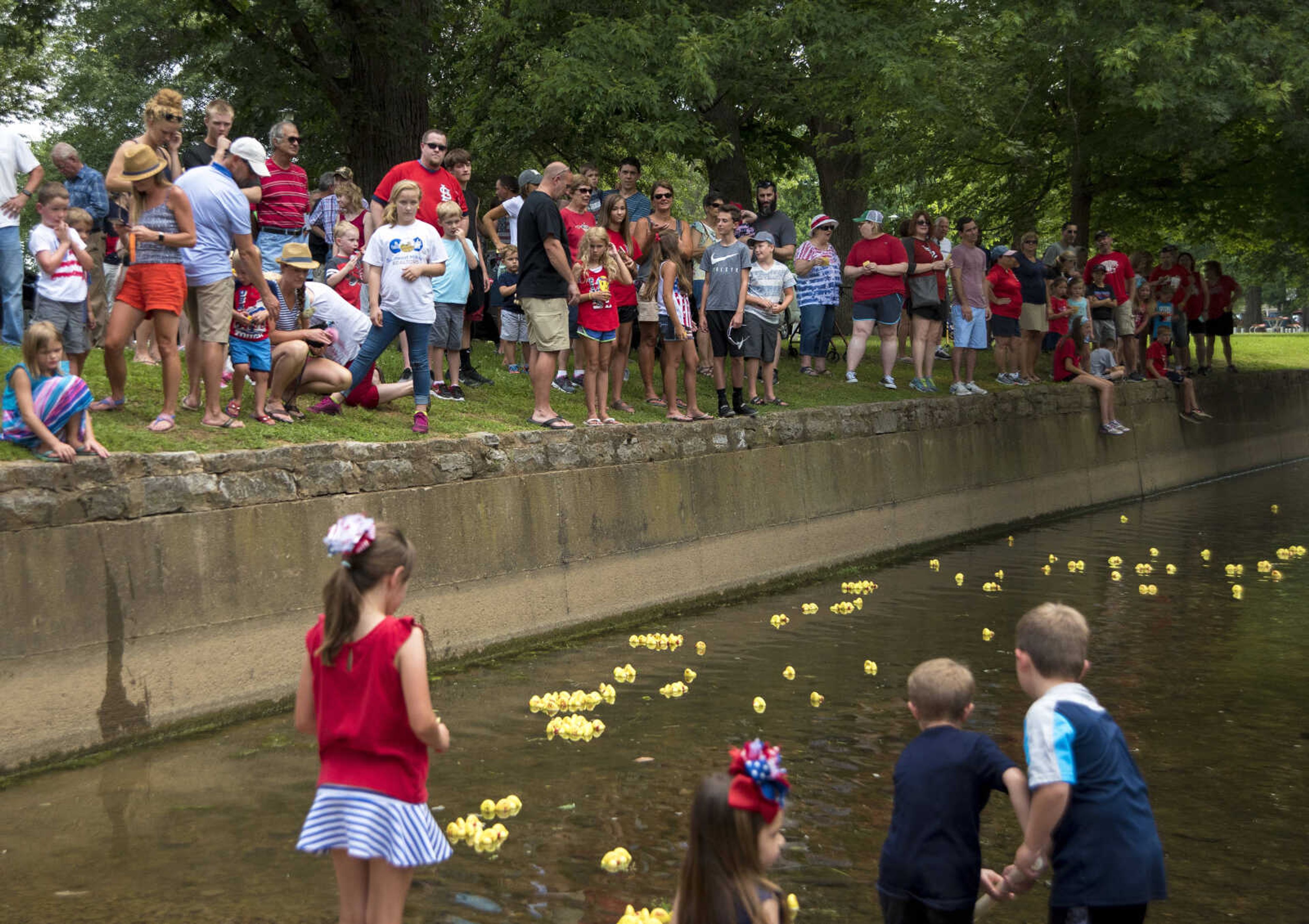 Kids pick up rubber ducks after the duck race for the Jackson Parks and Recreation's July 4th celebration Tuesday, July 4, 2017 in Jackson City Park.