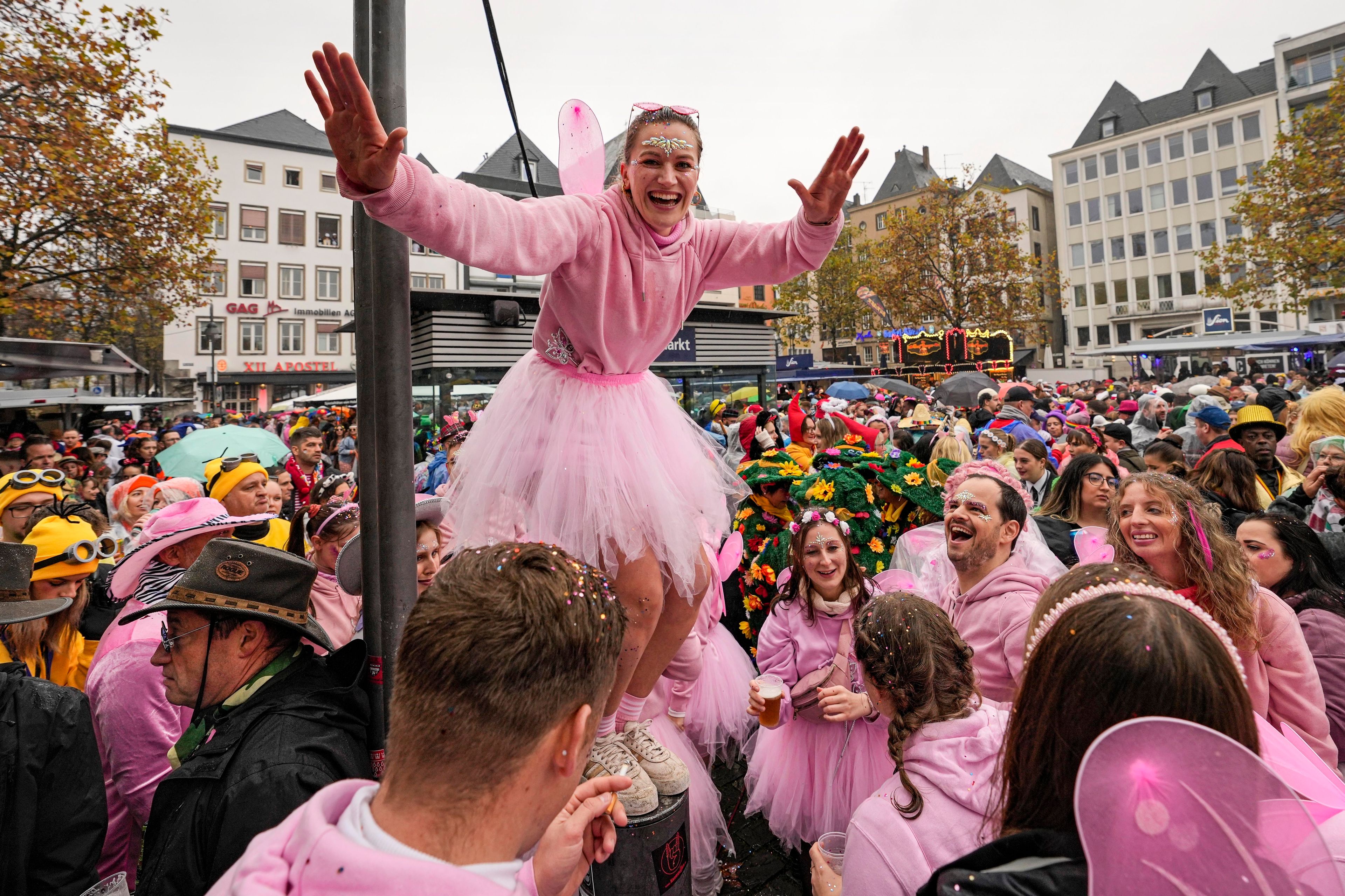 Costumed revelers celebrate at the central Heumarkt while tens of thousands of carnival fools take to the streets of Cologne, Germany, on Monday, November 11, 2024, heralding the official start of the carnival season. (AP Photo/Martin Meissner)