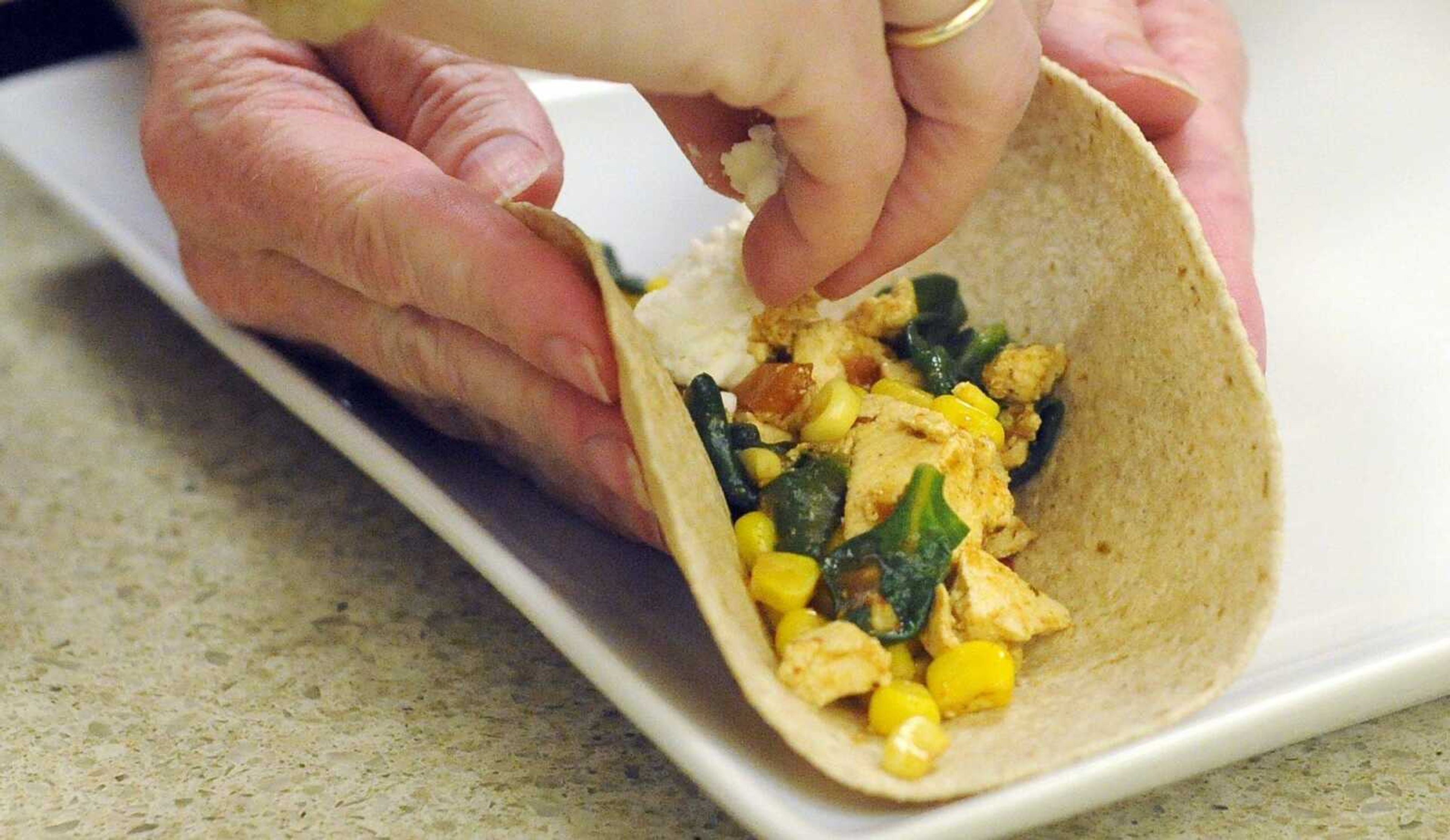 Feta cheese is sprinkled onto tofu tacos on Monday, May 30, 2016, during a tofu cooking class at HealthPoint Fitness in Cape Girardeau.