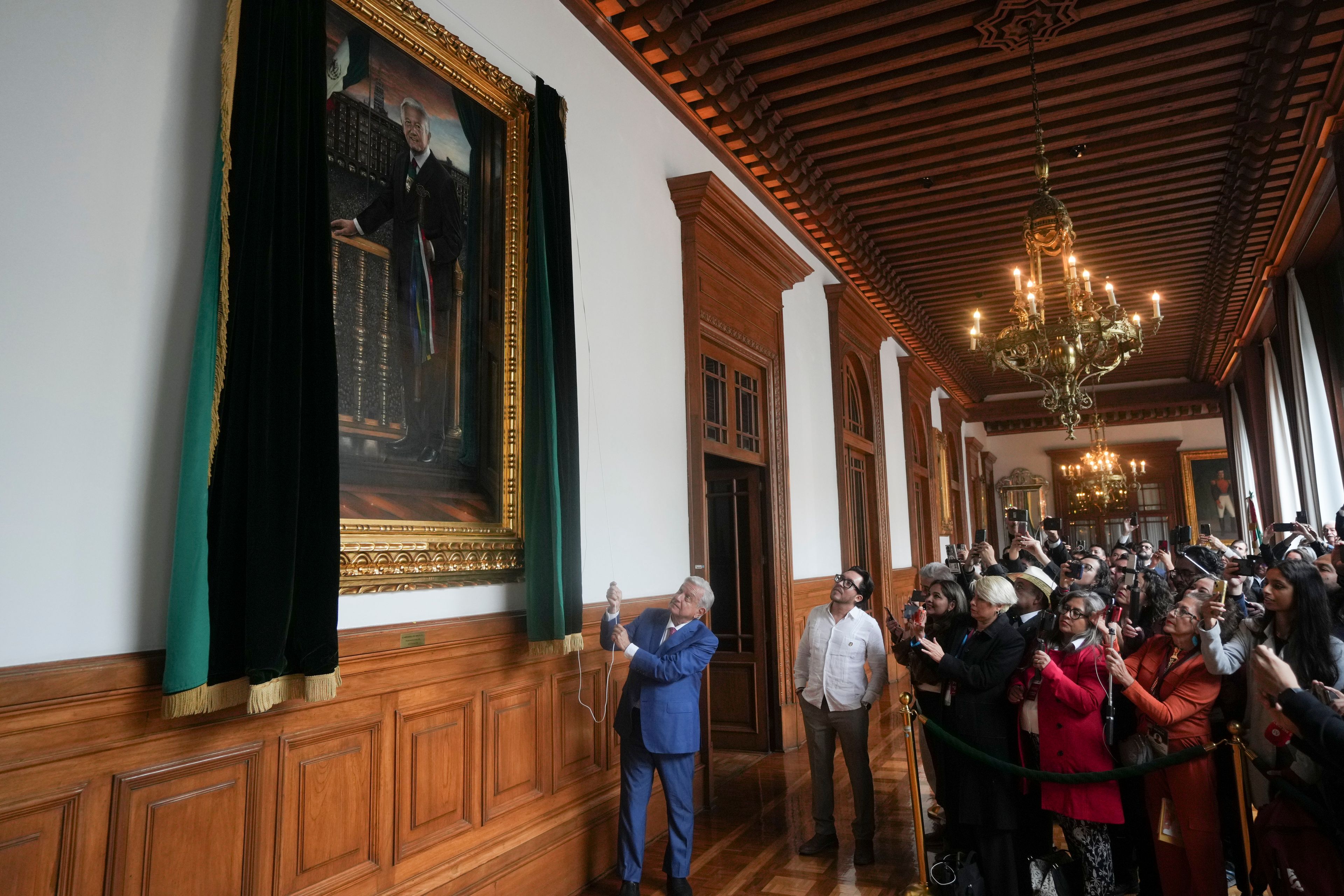 Mexican President Andres Manuel Lopez Obrador unveils his portrait at the National Palace after giving his last morning press conference, "La Mañanera," in Mexico City, Monday, Sept. 30, 2024. (AP Photo/Fernando Llano)