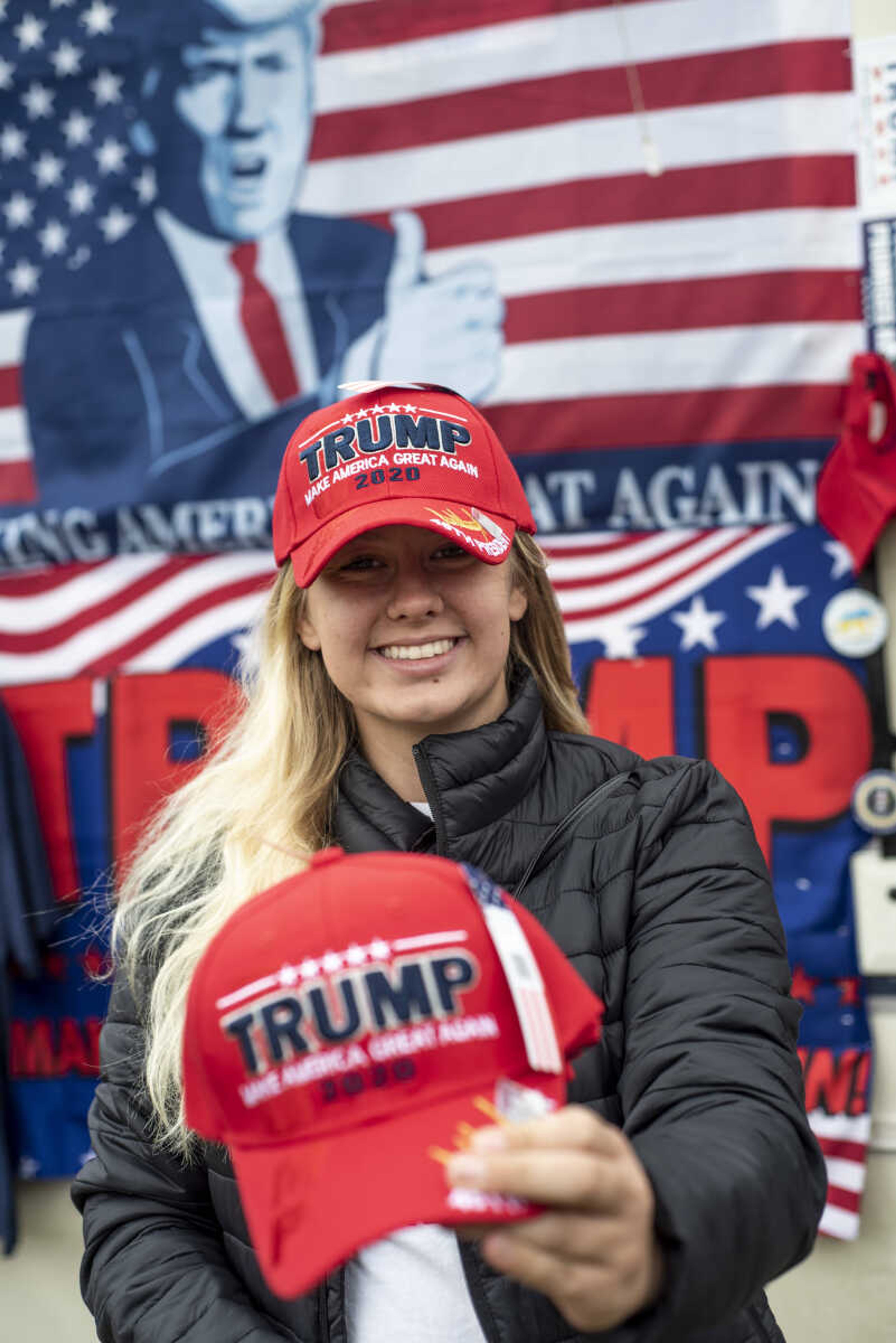 Jordon Burks, 18, holds a Trump 2020 hat as she poses for a photo outside of the RV she travels in to sell merchandise at Trump rallies at the Show Me Center Monday, Nov. 5, 2018, in Cape Girardeau.