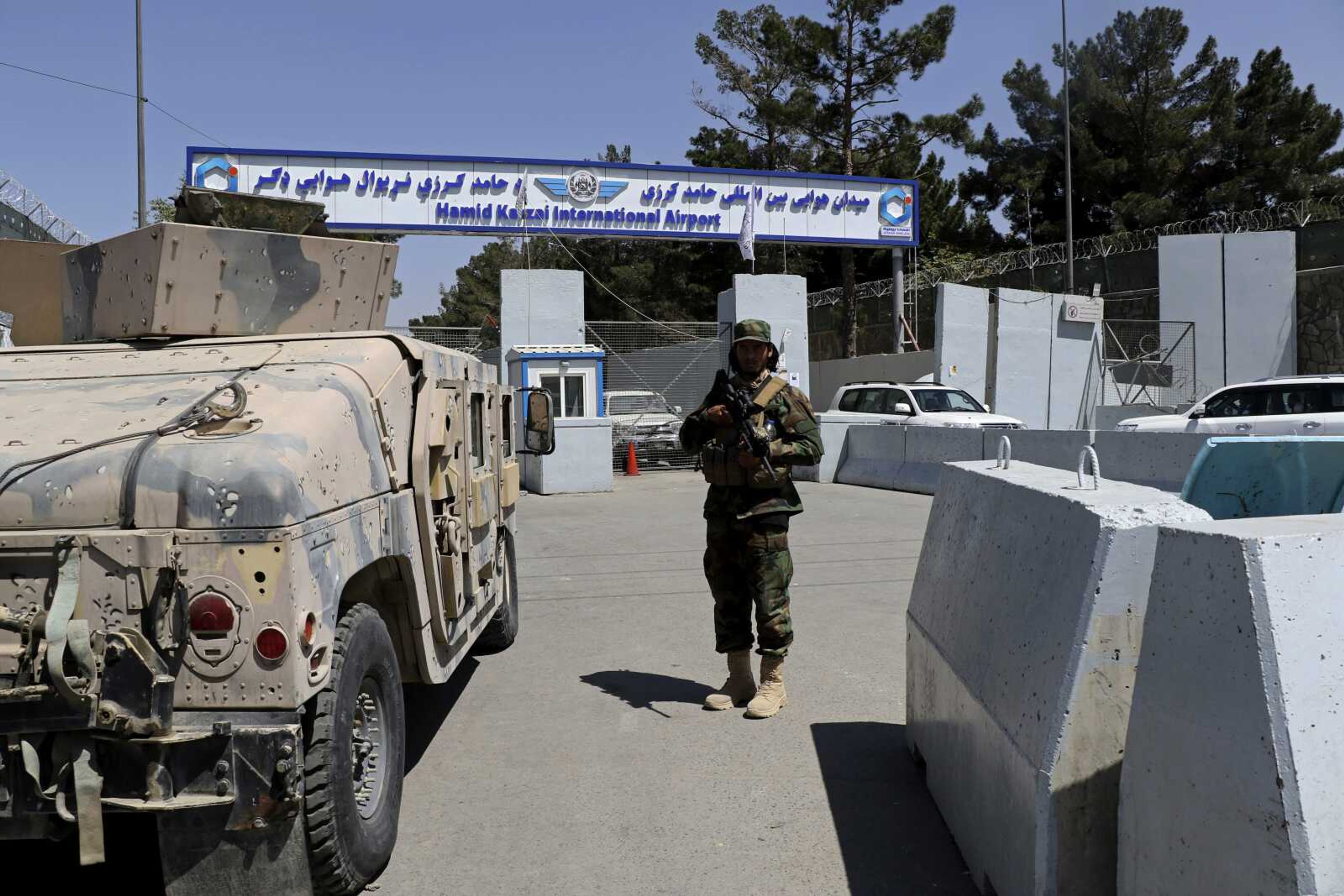 A Taliban soldier stands guard Sunday at the gate of Hamid Karzai International Airport in Kabul, Afghanistan. Some domestic flights have resumed at Kabul's airport, with the state-run Ariana Afghan Airlines operating flights to three provinces.