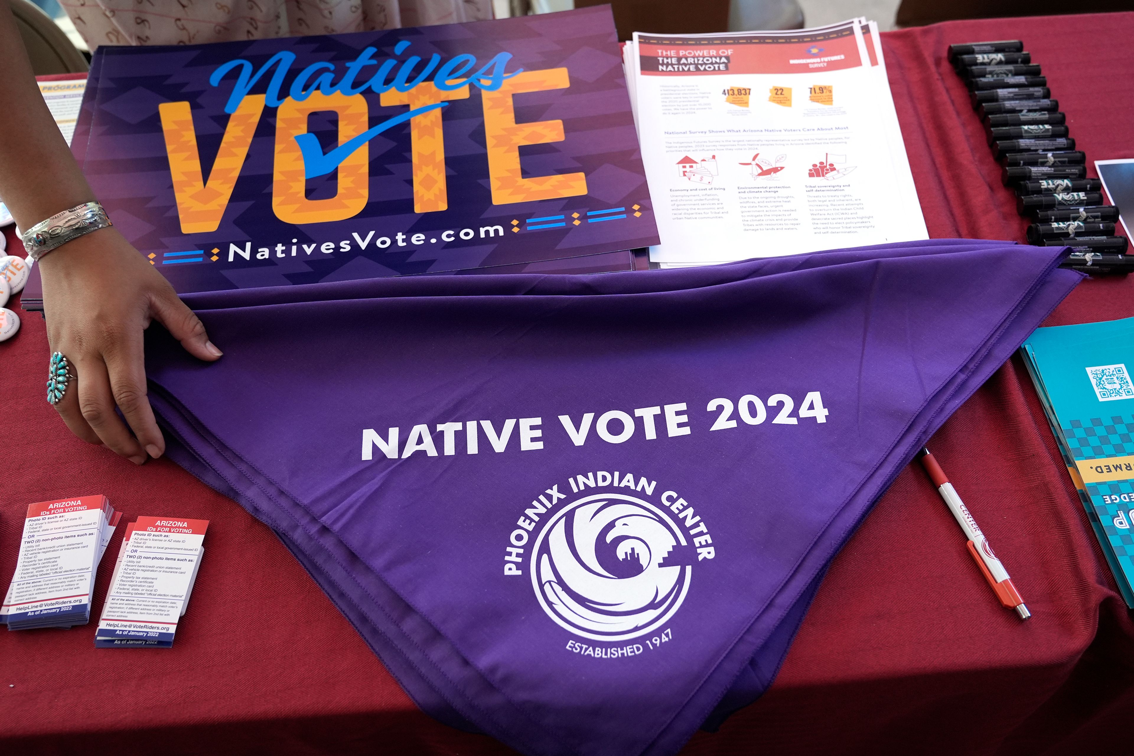 Voter information is on display at a Phoenix Indian Center booth during an Indigenous Peoples' Day event, Monday, Oct. 14, 2024, in Phoenix. (AP Photo/Ross D. Franklin)