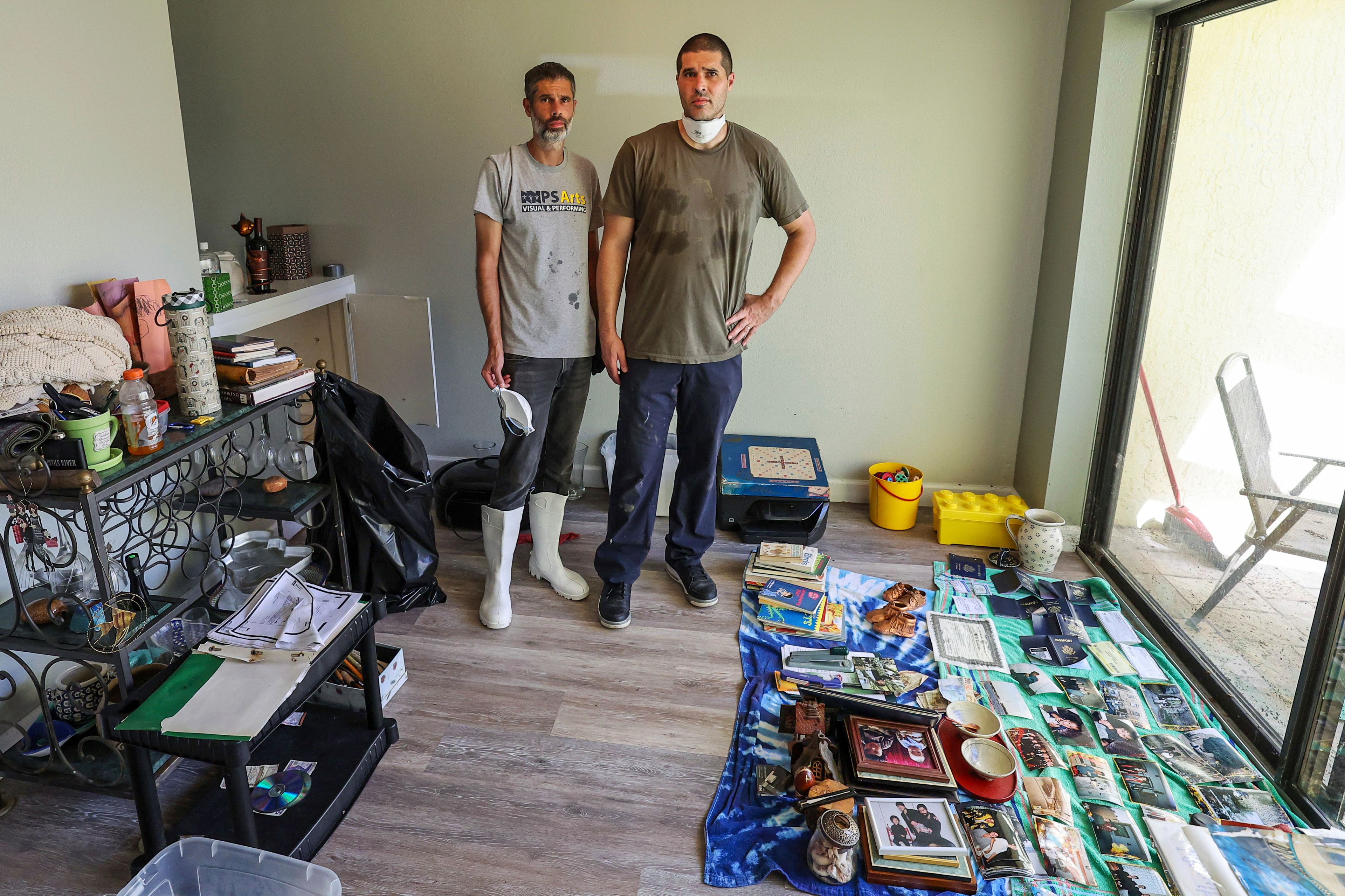 Miles Runner, left, and his brother Chris pause while cleaning out the home of their mother Donna Fagersten who died from flooding in Hurricane Helene on Wednesday, Oct. 2, 2024, in Indian Rocks Beach, Fla. (AP Photo/Mike Carlson)