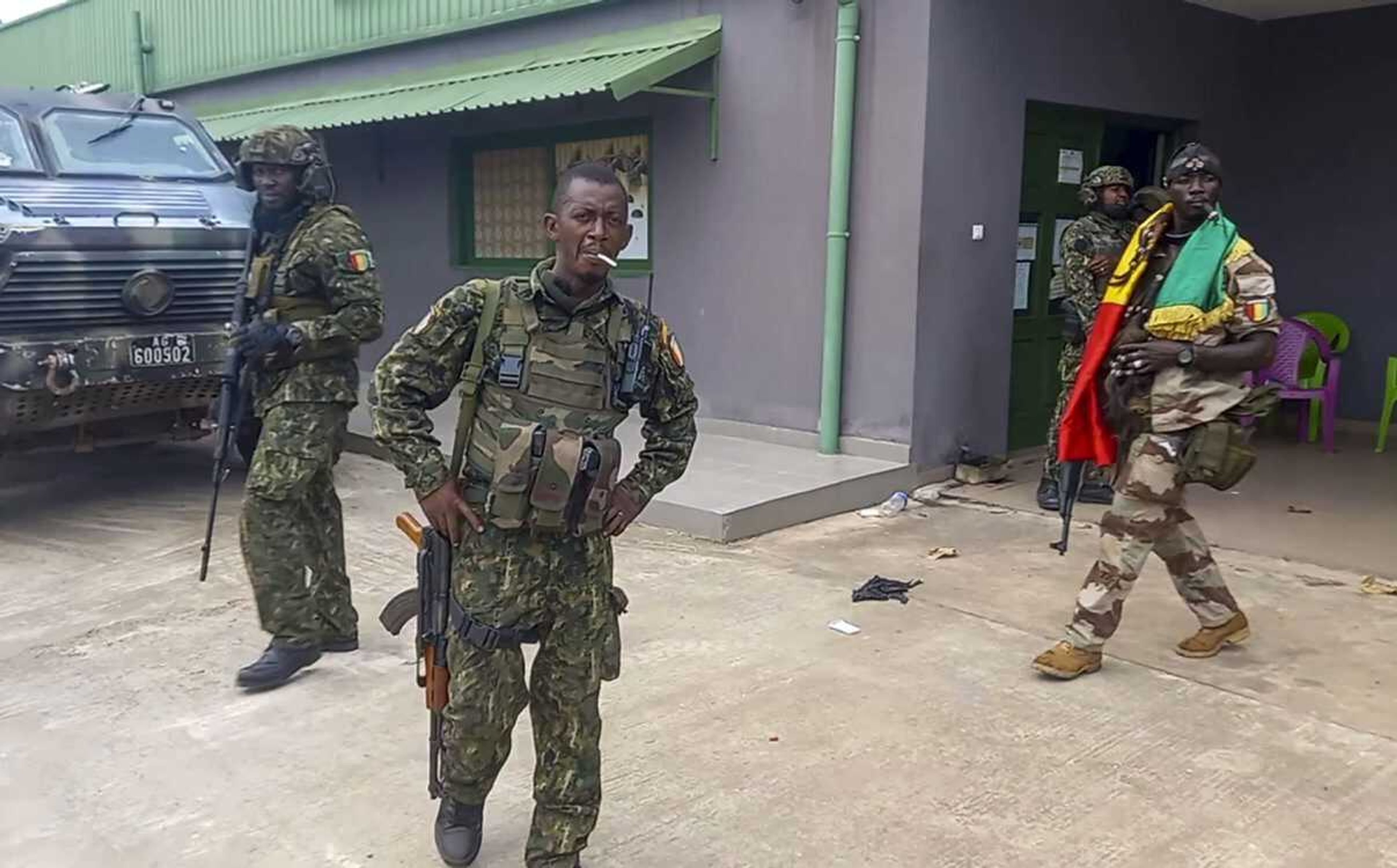 In this image made from video, unidentified soldiers patrol near the office of the president Sunday in the capital Conakry, Guinea.