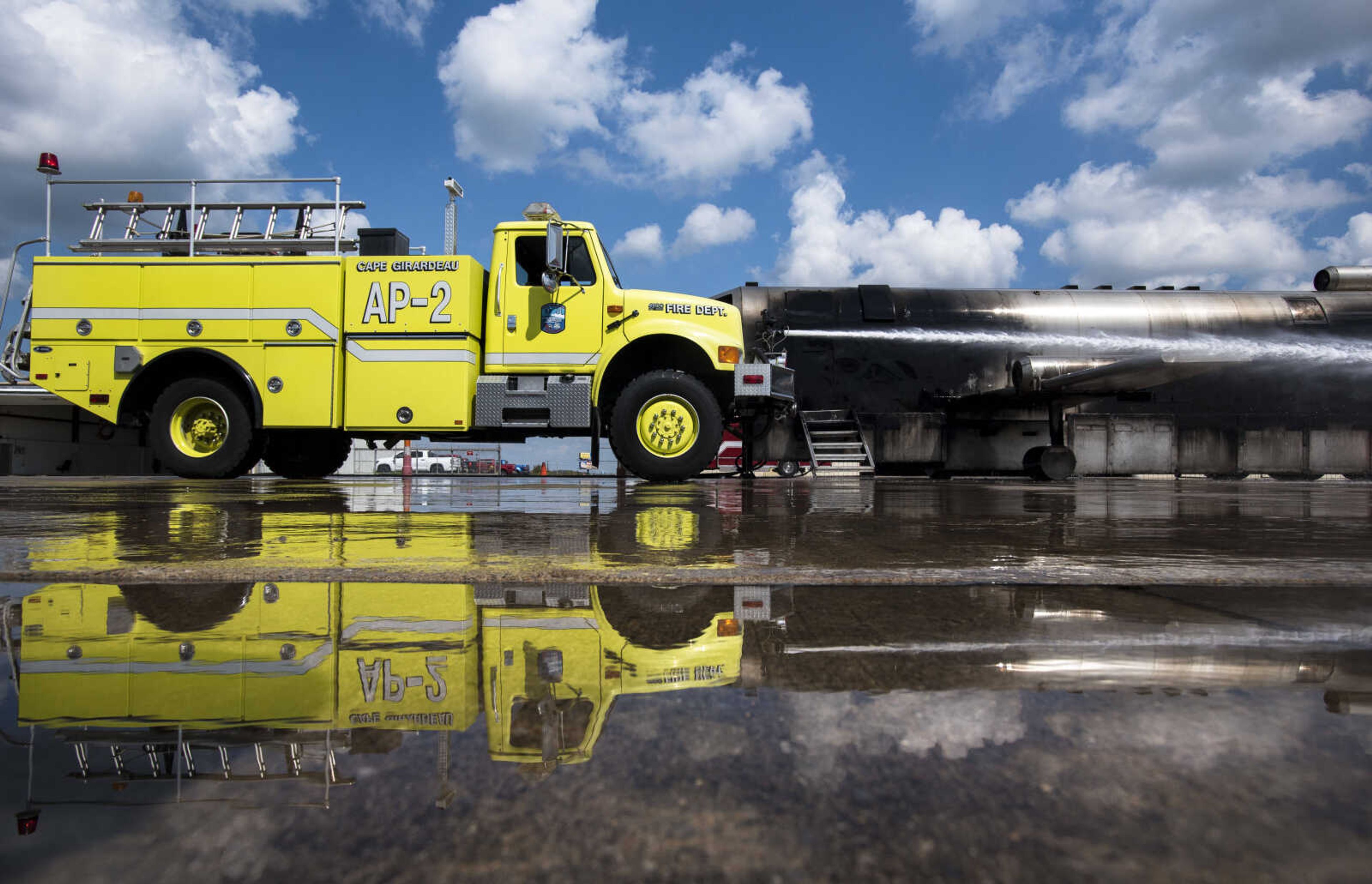 A firefighter guiding a firetruck hose puts out a ground fire and aircraft fire while area firefighters from Cape Girardeau, Gordonville and Scott City run airplane fire drills at the Cape Girardeau Regional Airport Friday morning, Sept. 15, 2017 in Cape Girardeau.