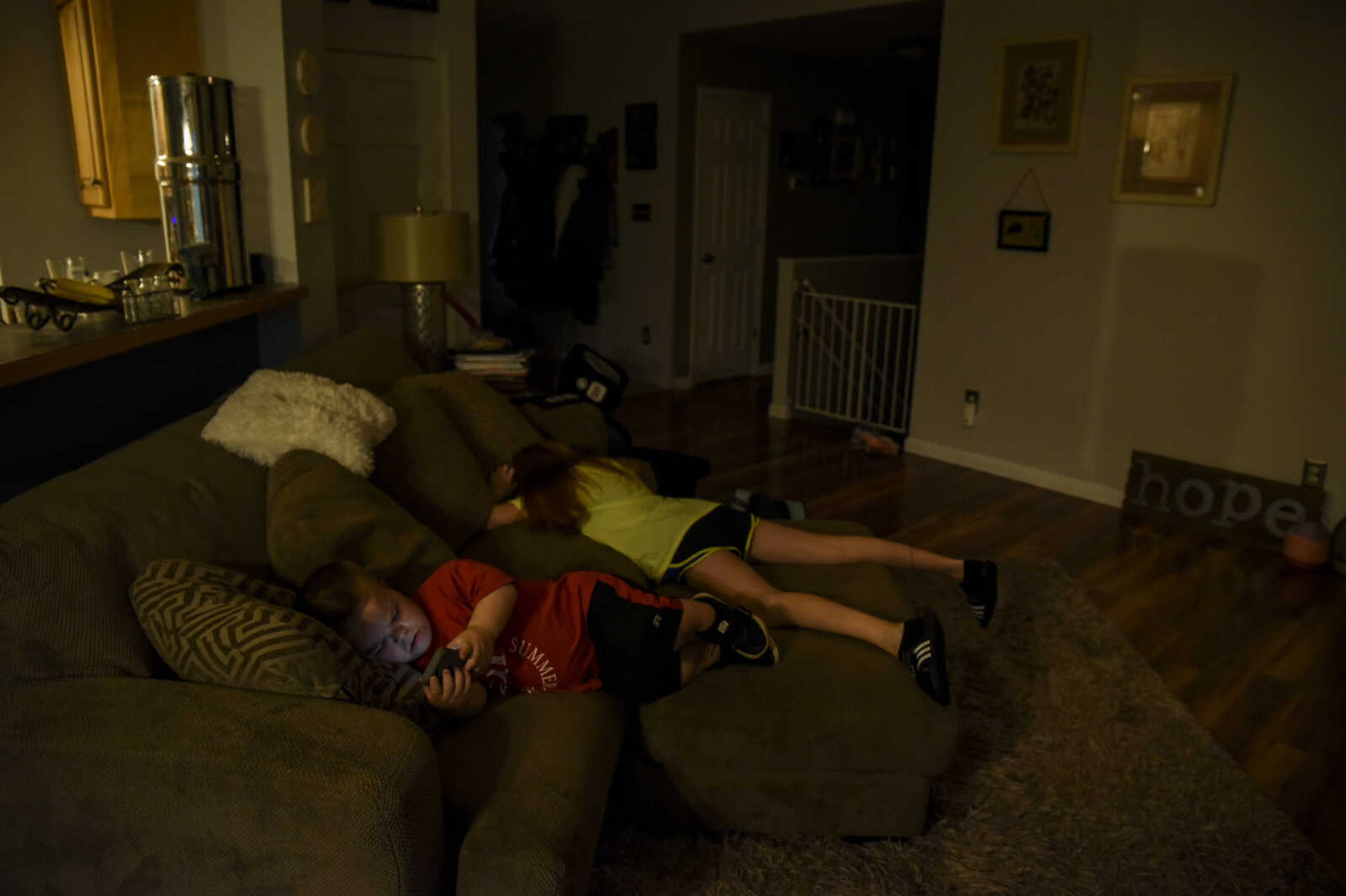 Izaac Pursley lays on the couch with his big sister Evee-Kay Pursley before heading to the bus stop May 3, 2018, at their home in Jackson.