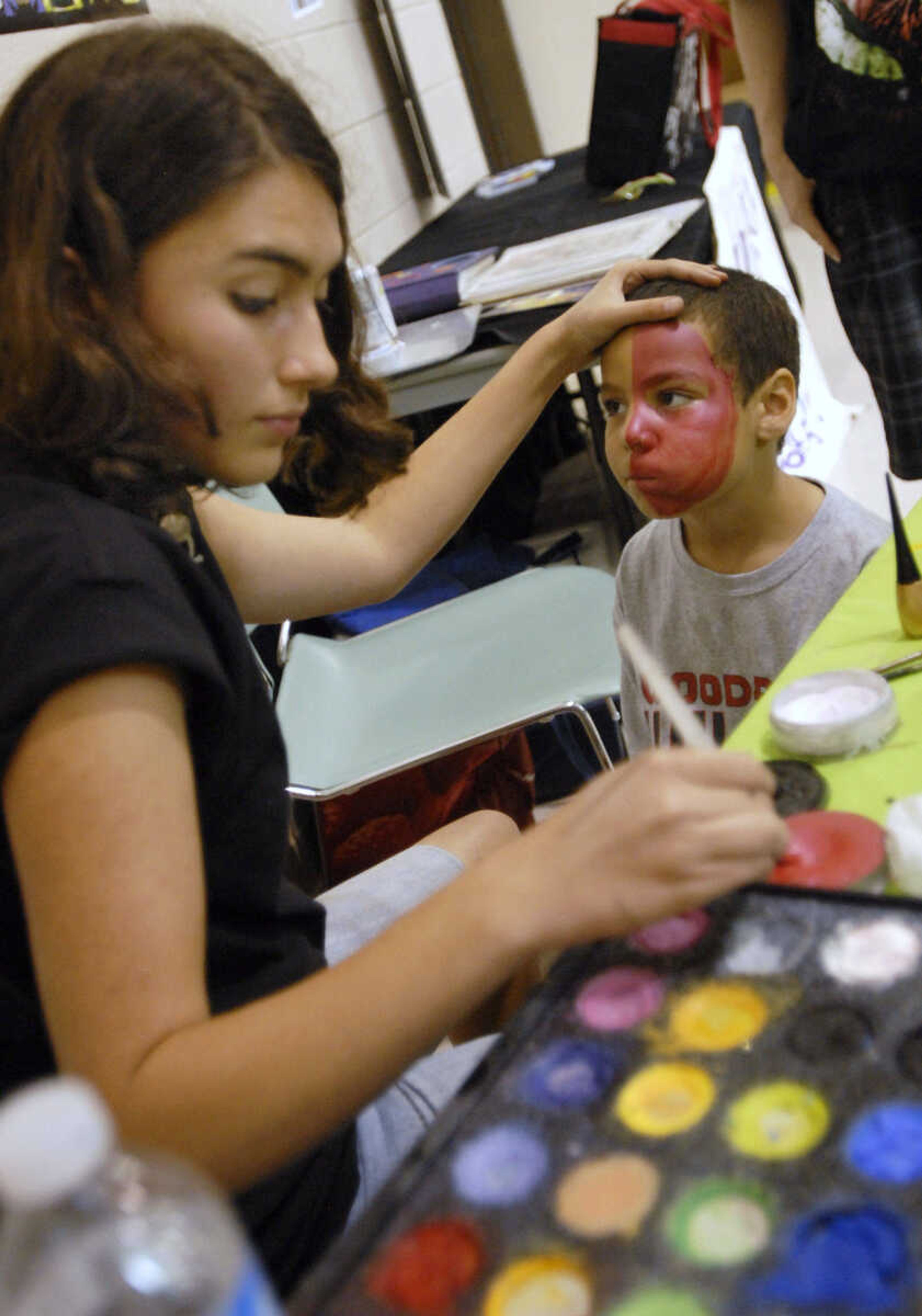 KRISTIN EBERTS ~ keberts@semissourian.com

Tessa Valleroy paints the face of Nathan McGuinn, 6, during the sixth annual Cape Comic Con on Saturday, June 25, 2011, at the Osage Centre in Cape Girardeau.