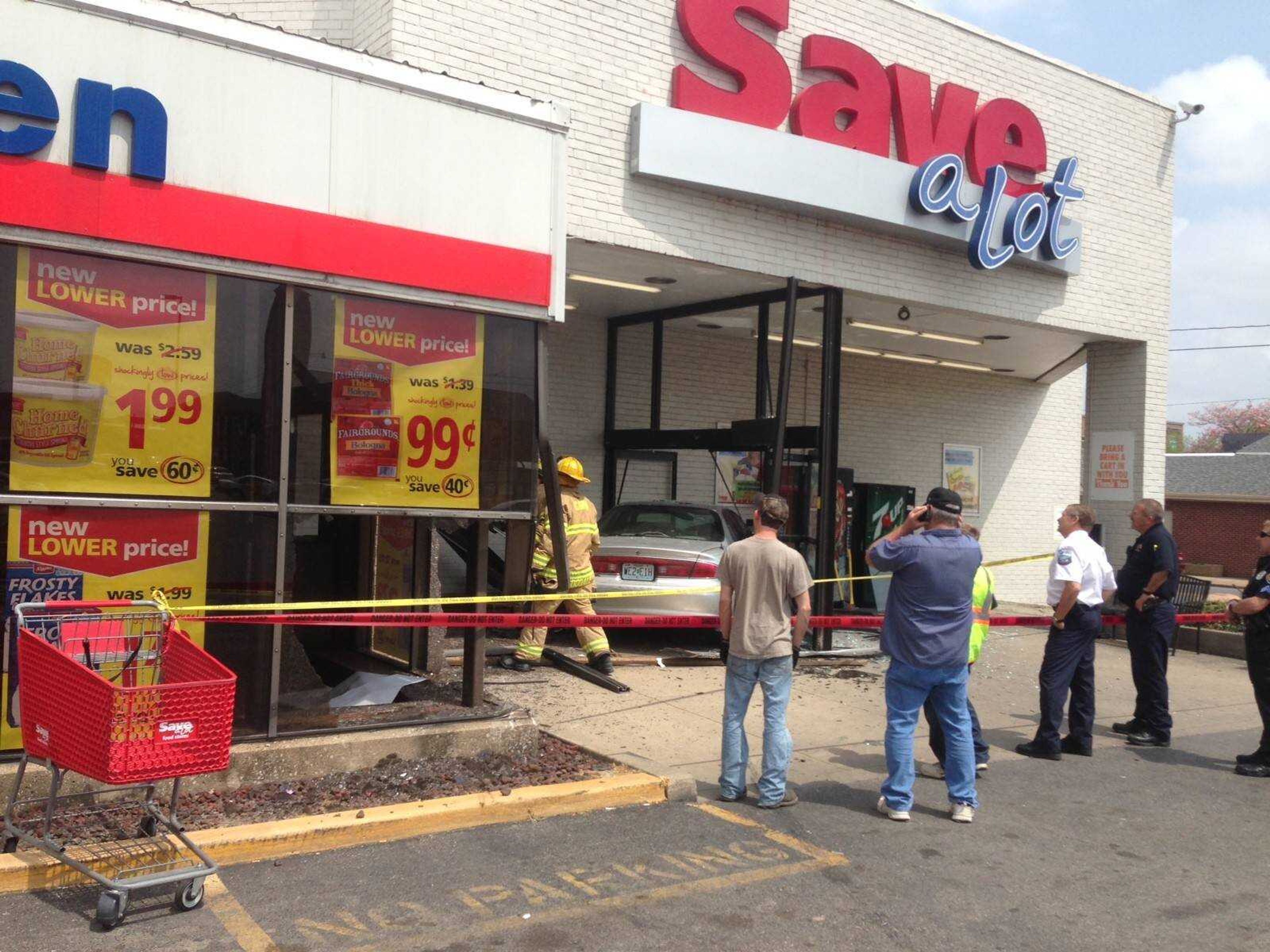 Police, fire and bystanders at Save-A-Lot early Wednesday afternoon, where a car crashed through the store's front entrance. (Adam Vogler)