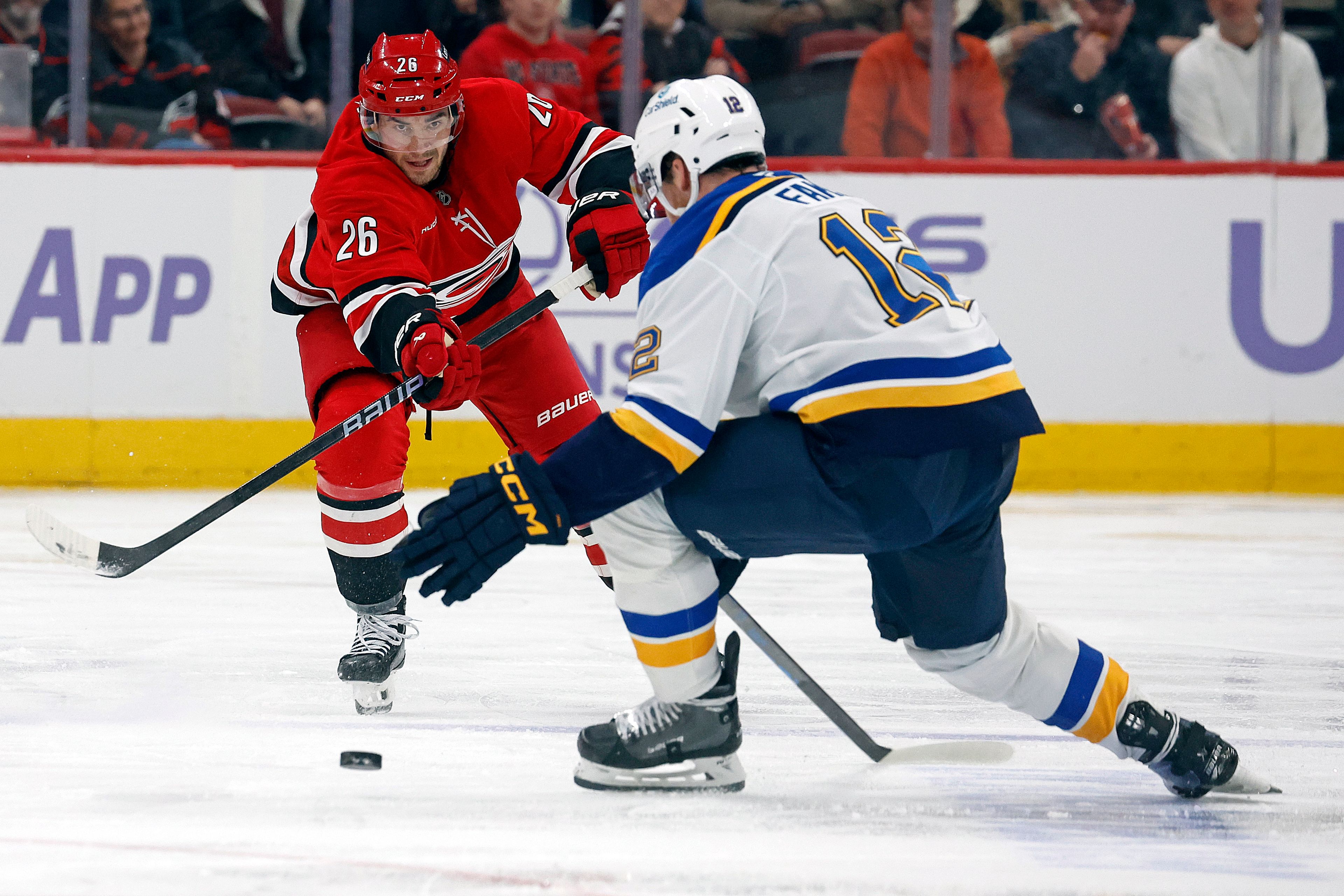 Carolina Hurricanes' Sean Walker (26) clears the puck past St. Louis Blues' Radek Faksa (12) during the second period of an NHL hockey game in Raleigh, N.C., Sunday, Nov. 17, 2024. (AP Photo/Karl B DeBlaker)