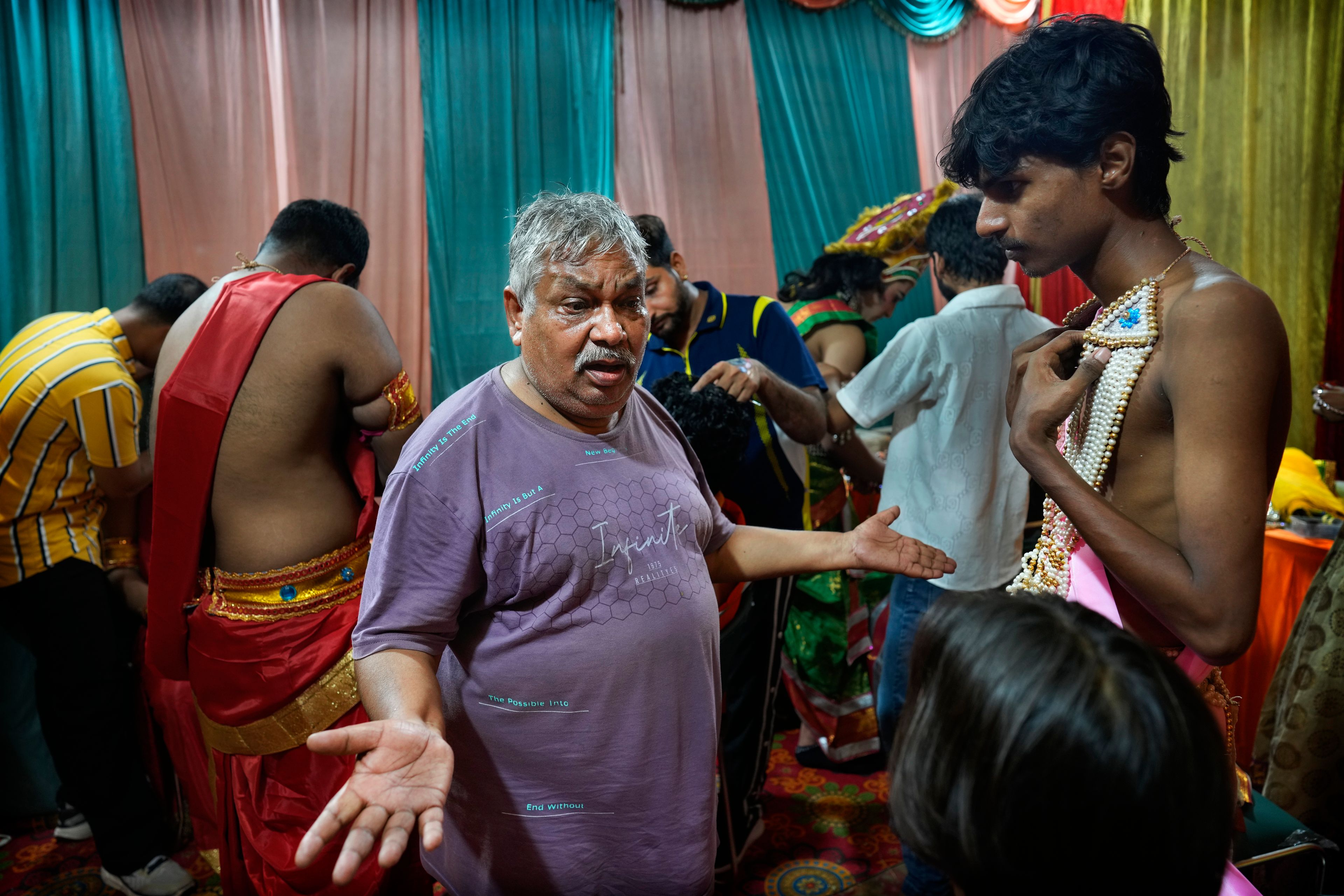 Theatre director Rakesh Ratnakar, 65, gives instructions to the actors backstage before the start of Ramleela, a dramatic folk re-enactment of the life of Hindu god Rama according to the ancient Hindu epic Ramayana, in New Delhi, India, Saturday, Oct. 5, 2024. (AP Photo/Manish Swarup)