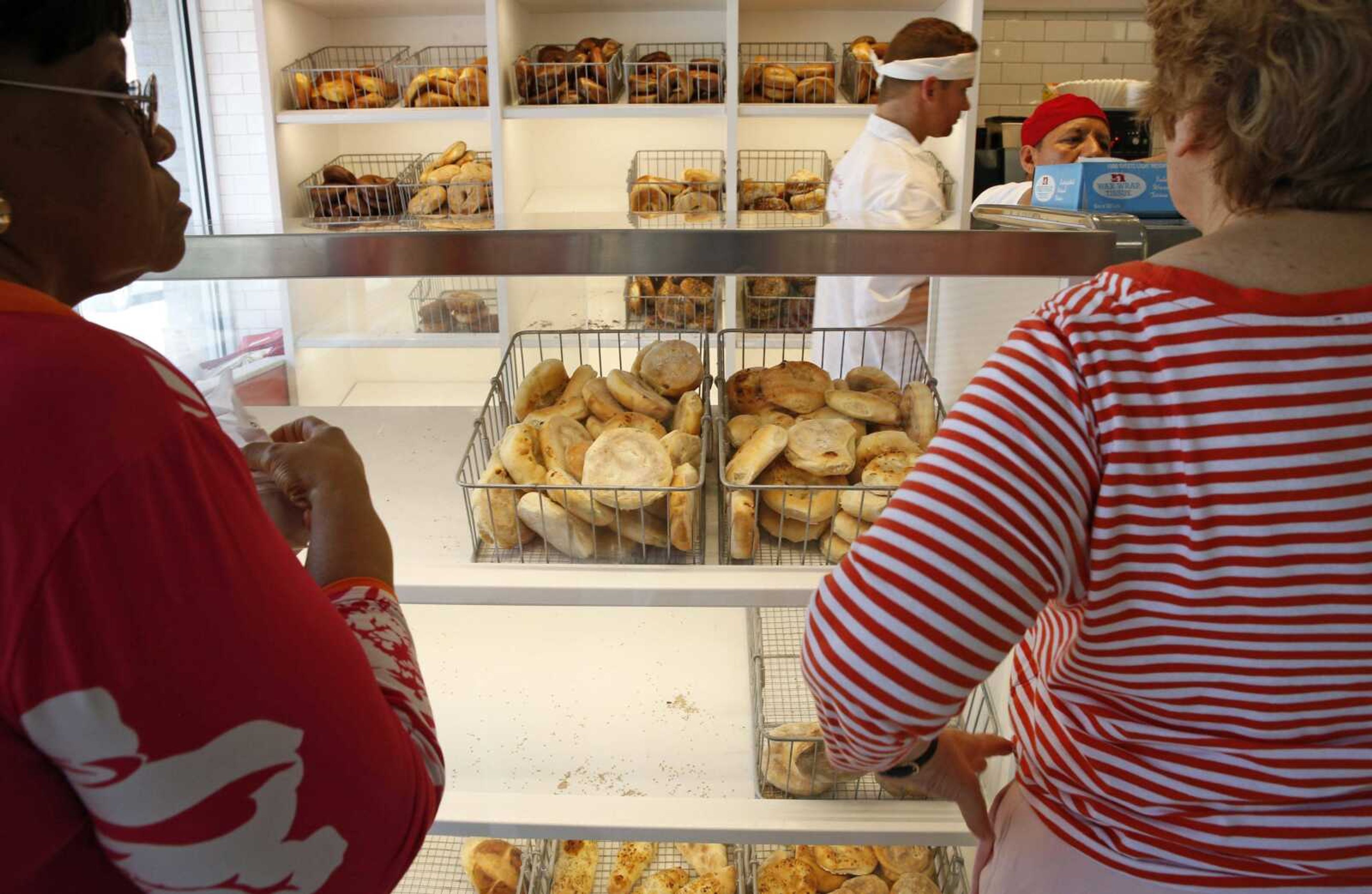 Customers wait at the counter to place an order food at Kossar's Bagels and Bialys in New York on Thursday, May 26. Located in the Lower East Side, a traditional immigrant neighborhood, Kossar's is known more for its bialys than bagels. (AP Photo/Kathy Willens)