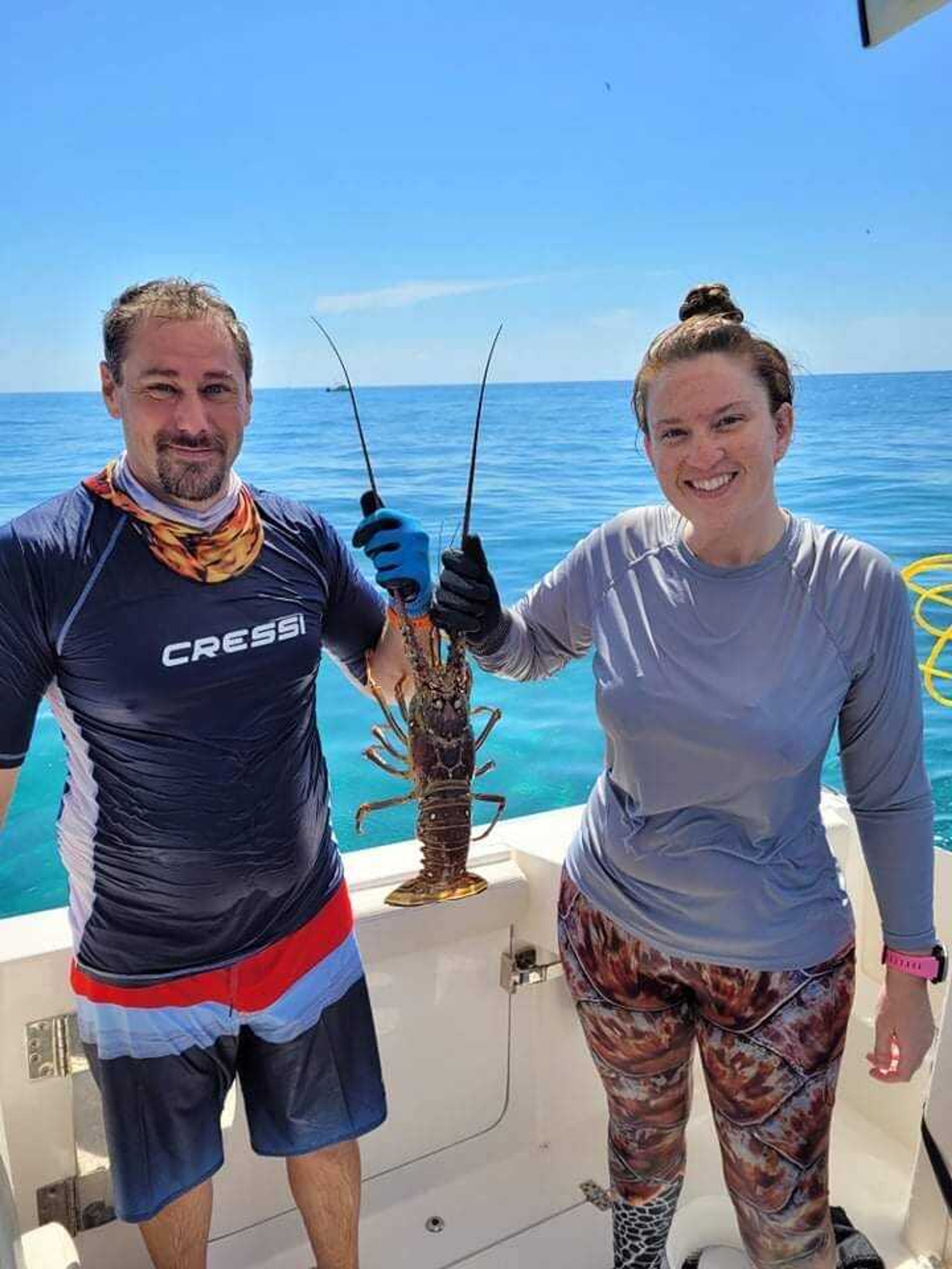 Quentin and Amber Kimbrell hold up a lobster they caught on a boat in the Florida Keys. The couple started lobster hunting in 2018 and fell in love with the hobby. They catch approximately 100 lobsters every season. 