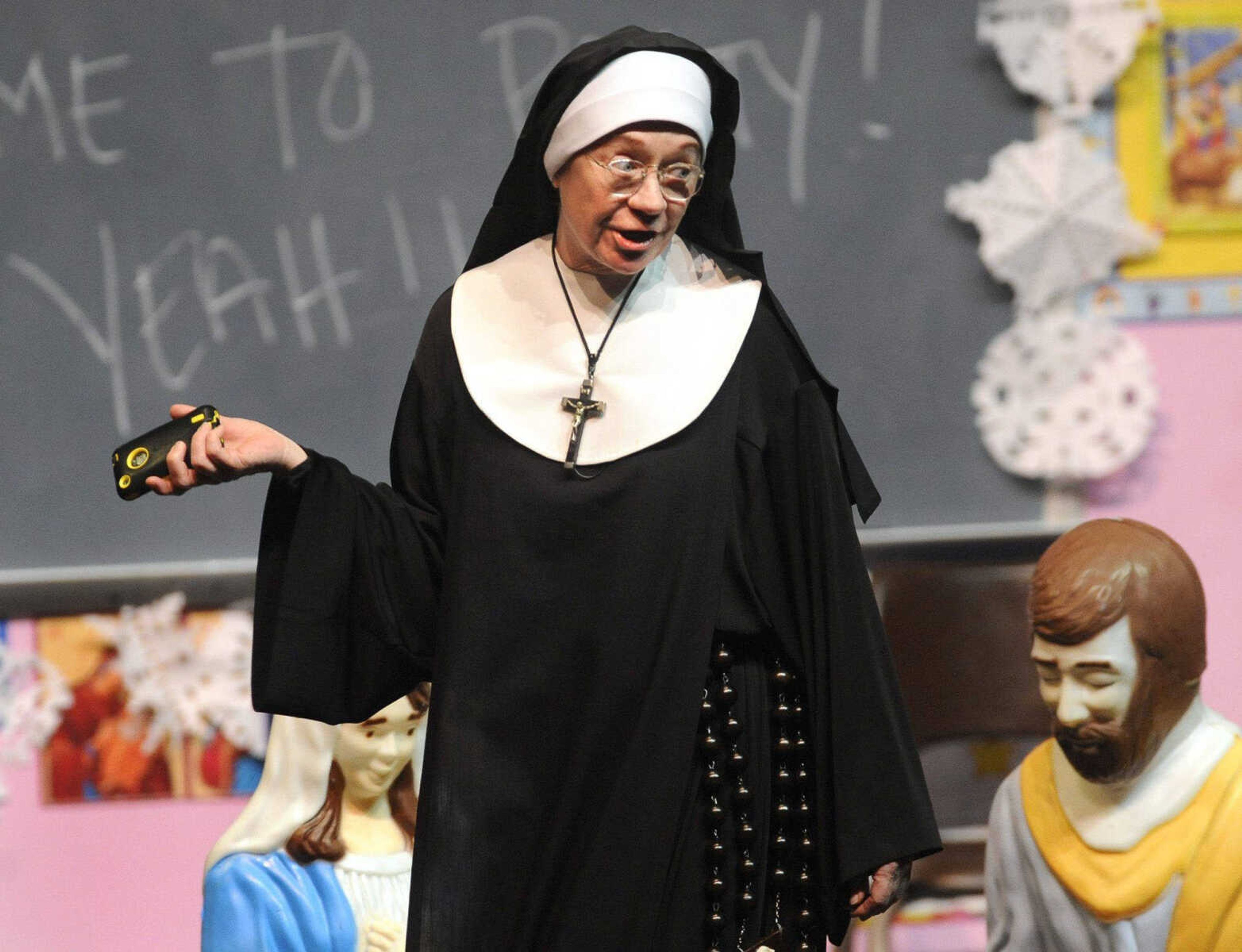 Kim Richards confiscates a cellphone from the audience Dec. 11, 2011 while performing "Sister's Christmas Catechism" at Bedell Performance Hall on the River Campus. (Fred Lynch)