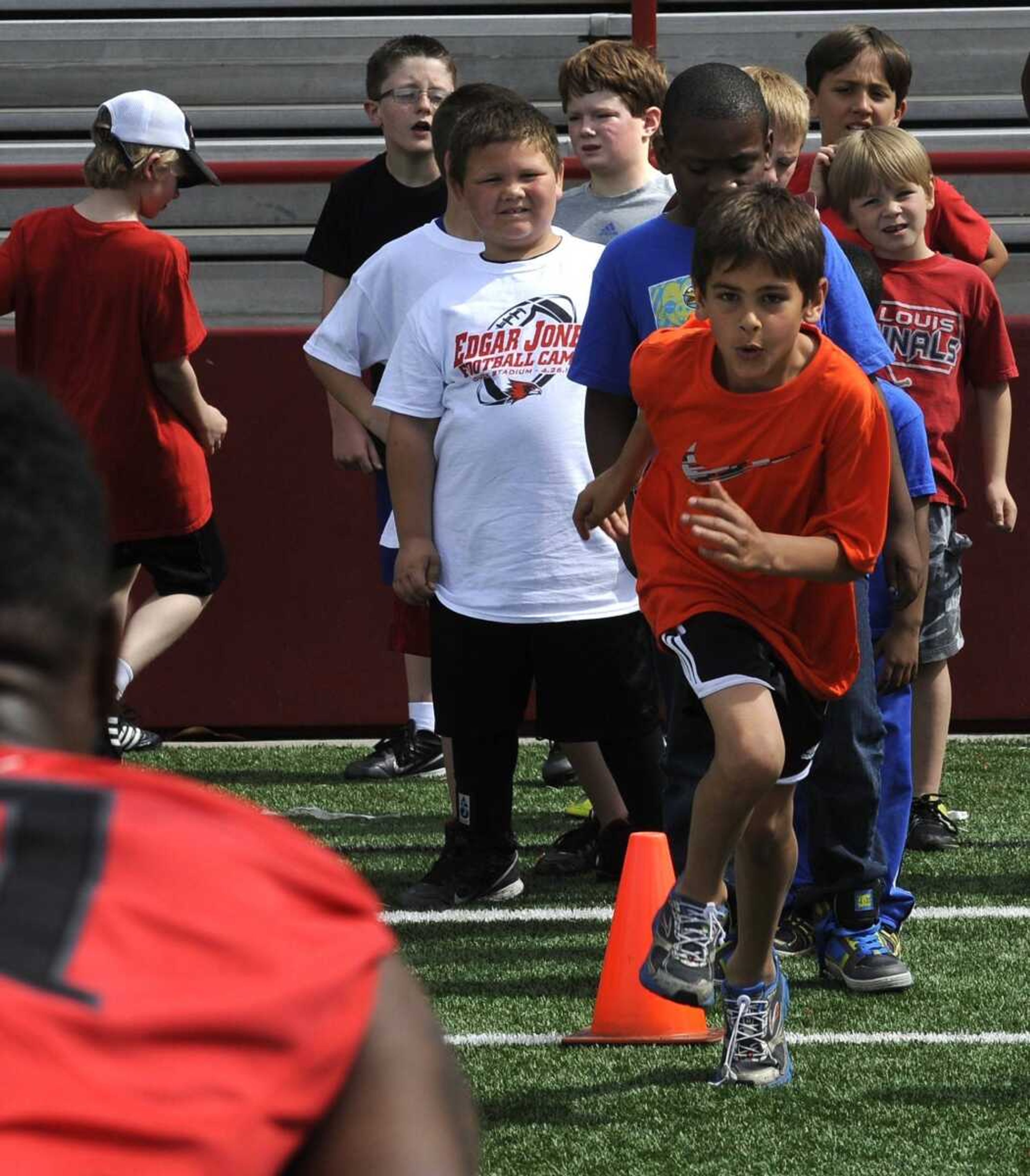 A child runs toward a Southeast Missouri State football player during a football camp Saturday at Houck Stadium. (Fred Lynch)