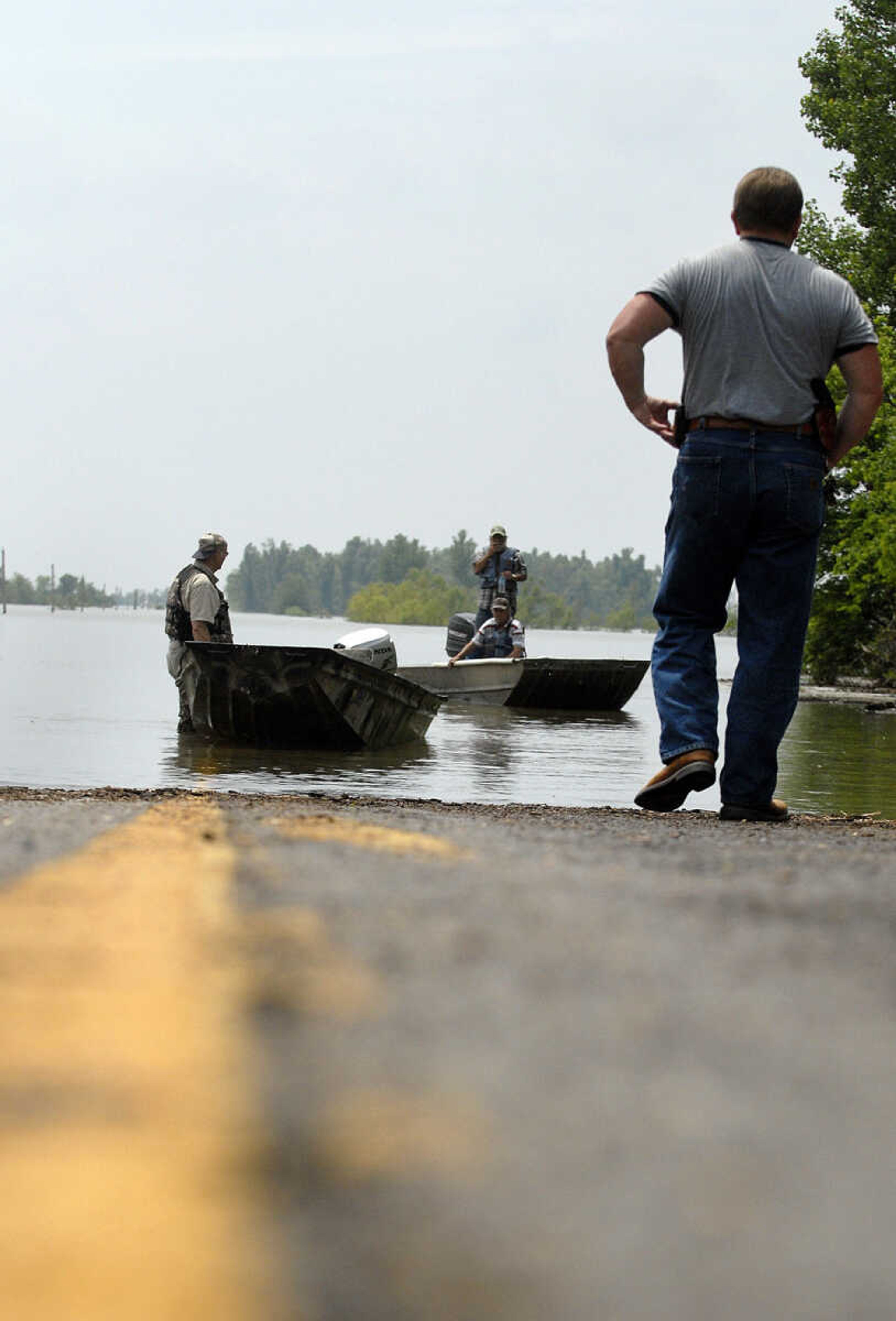 LAURA SIMON~lsimon@semissourian.com
Mississippi County Sheriff Keith Moore walks towards land owners as they return to Highway 102 Monday, May 9, 2011 after checking on their property in the floodway in Mississippi County.