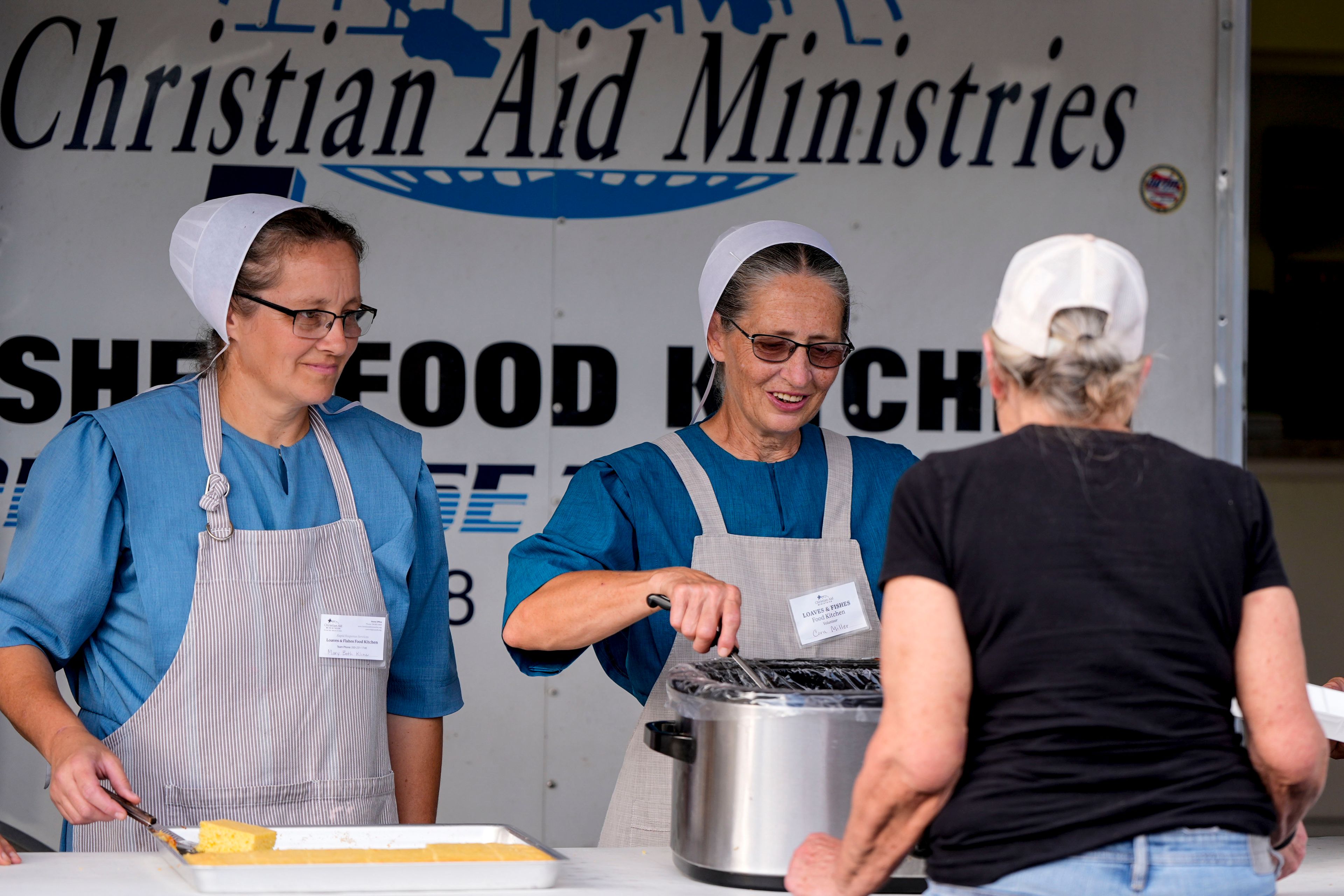 Loaves & Fishes food group serve meals for residents in the aftermath of Hurricane Helene, Wednesday, Oct. 2, 2024, in Lake Lure, N.C. (AP Photo/Mike Stewart)