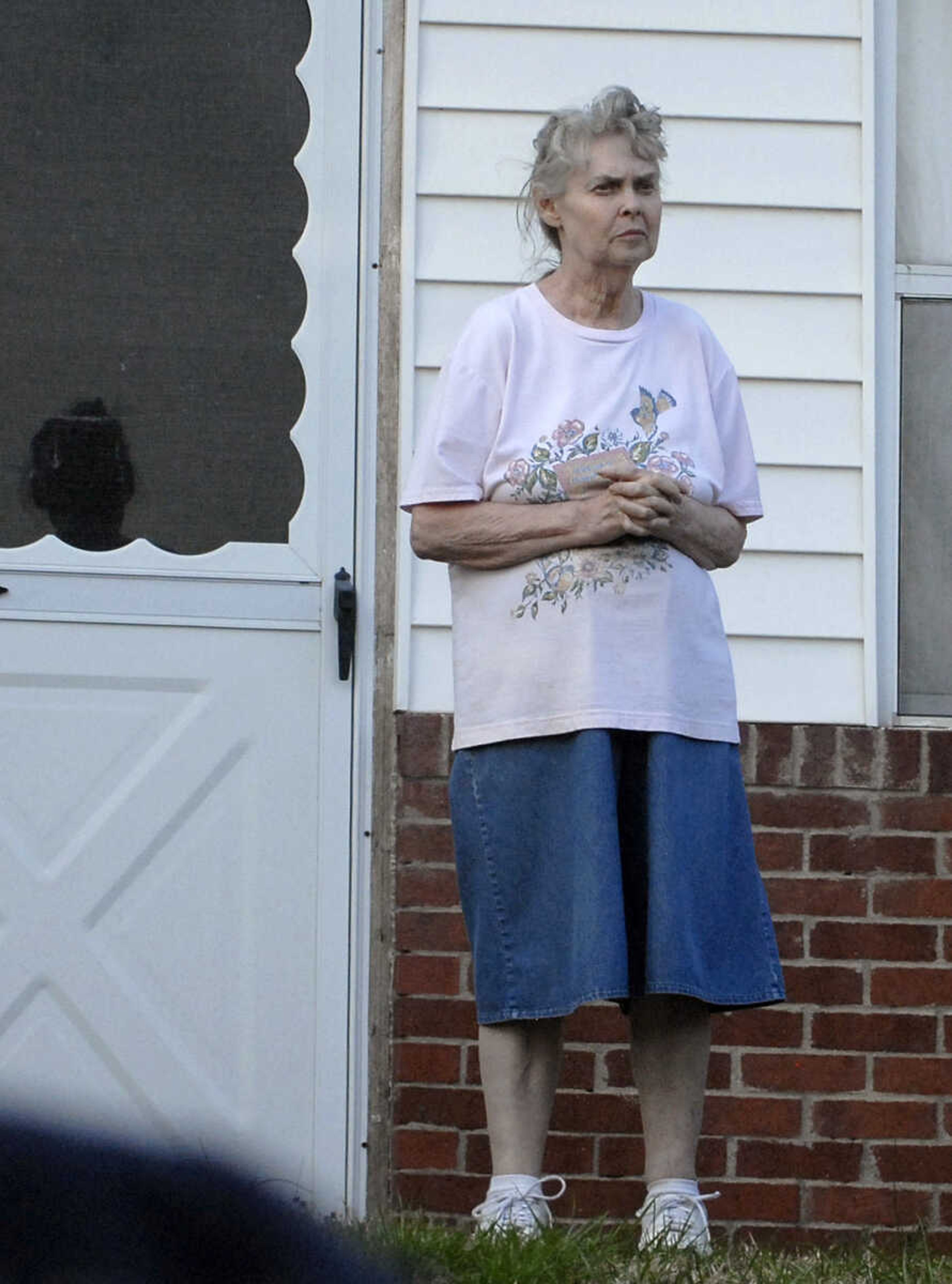 LAURA SIMON~lsimon@semissourian.com
Homeowner Delores Tackett watches from her front yard as firefighters  try to control a natural cover fire off of Cissus Lane near Neelys Landing Sunday, April 3, 2011. Firefighters from Cape Girardeau, Perry, Scott, and Bollinger Counties contained the blaze that ravaged 50 acres of land.