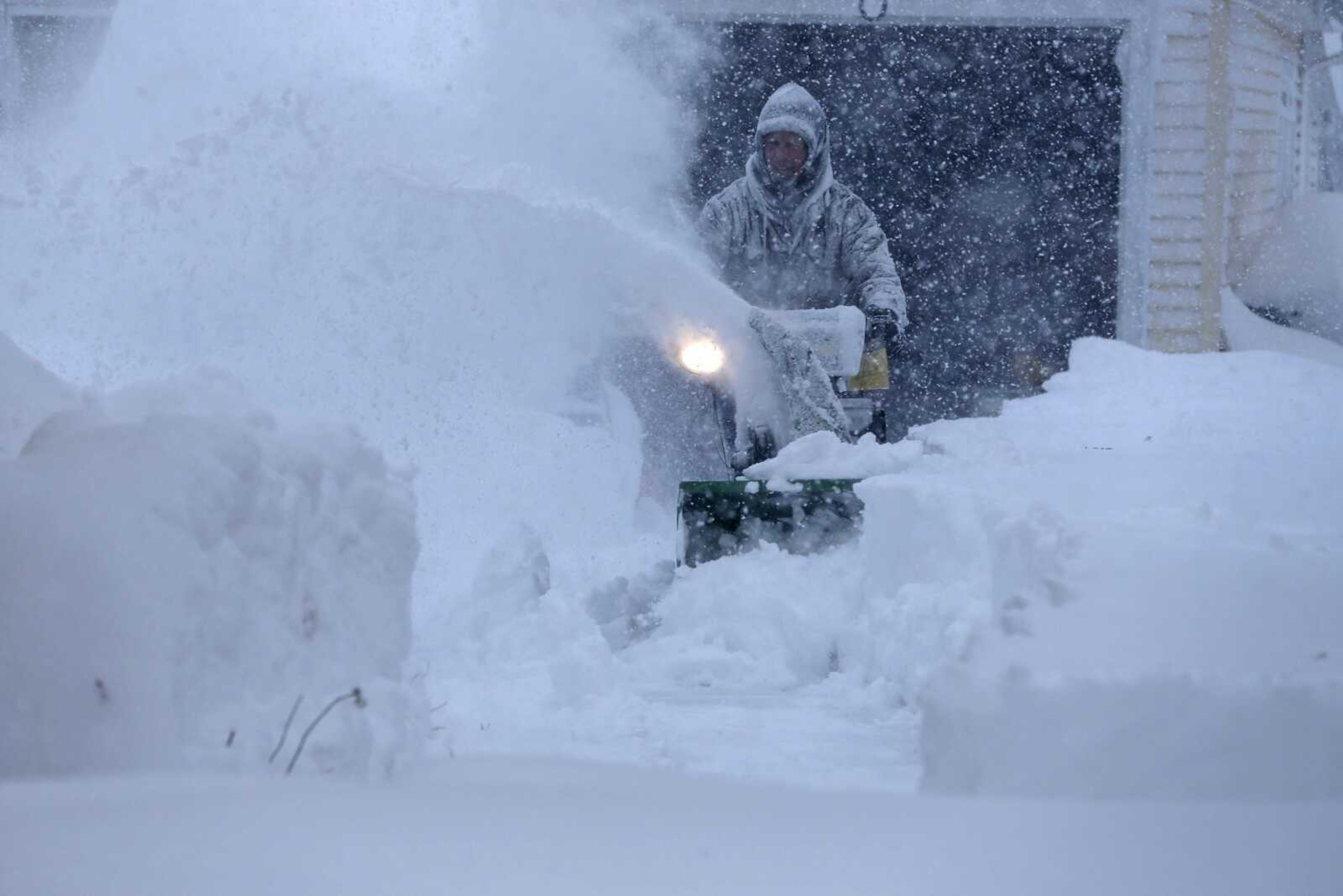 Jerry Delzer attempts to clear the snow in his driveway Tuesday in Depew, New York. Several feet of lake-effect snow paralyzed the Buffalo area Tuesday, forcing state troopers to deliver blankets and other supplies to stranded motorists. (Derek Gee ~ The Buffalo News)