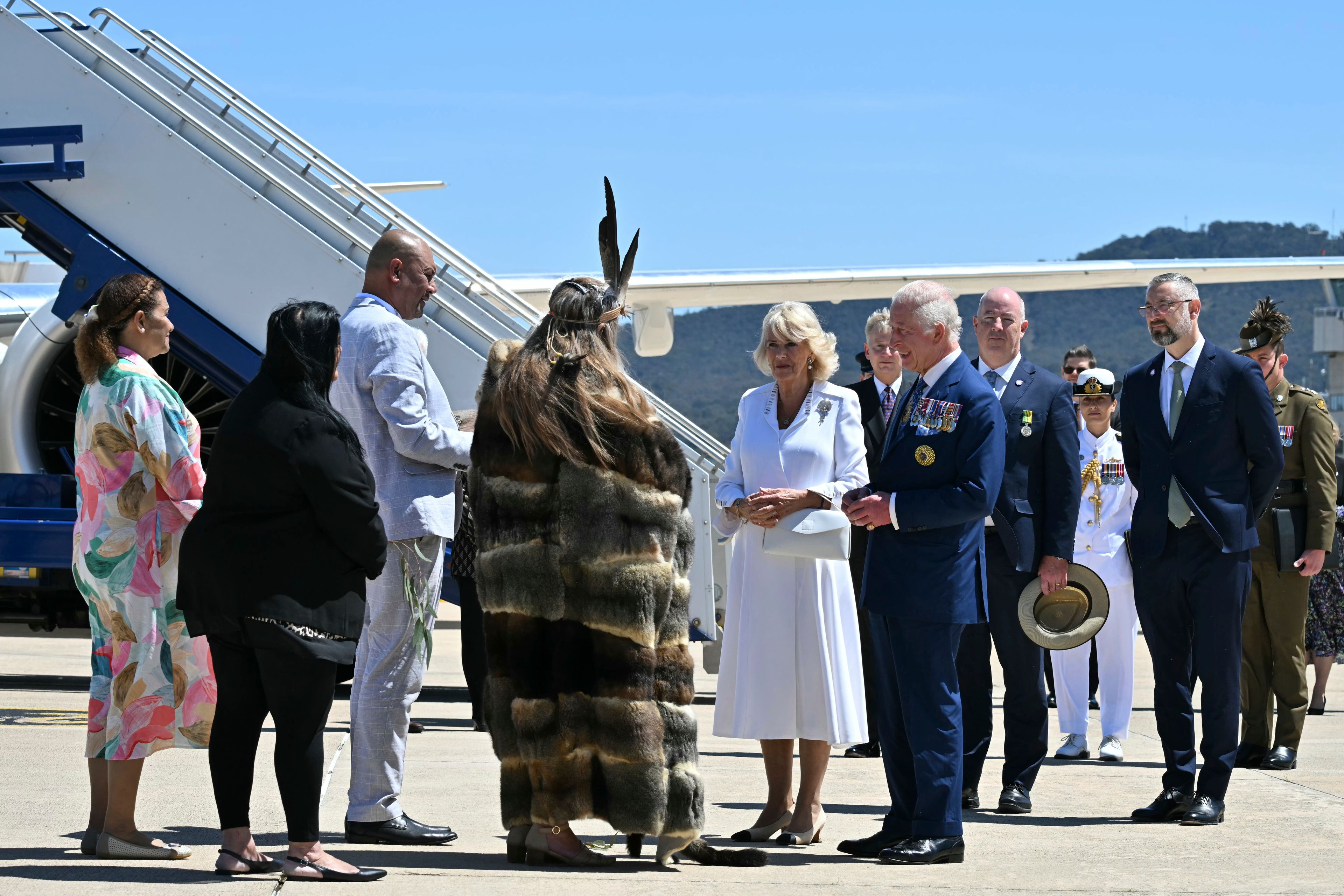 Britain's King Charles III, center right, and Queen Camilla, center left, are greeted by Ngunnawal Elder Aunty Serena Williams, fourth from left, after arriving at the Defense Establishment Fairbairn in Canberra, Australia, Monday, Oct. 21, 2024. (Saeed Khan/Pool Photo via AP)