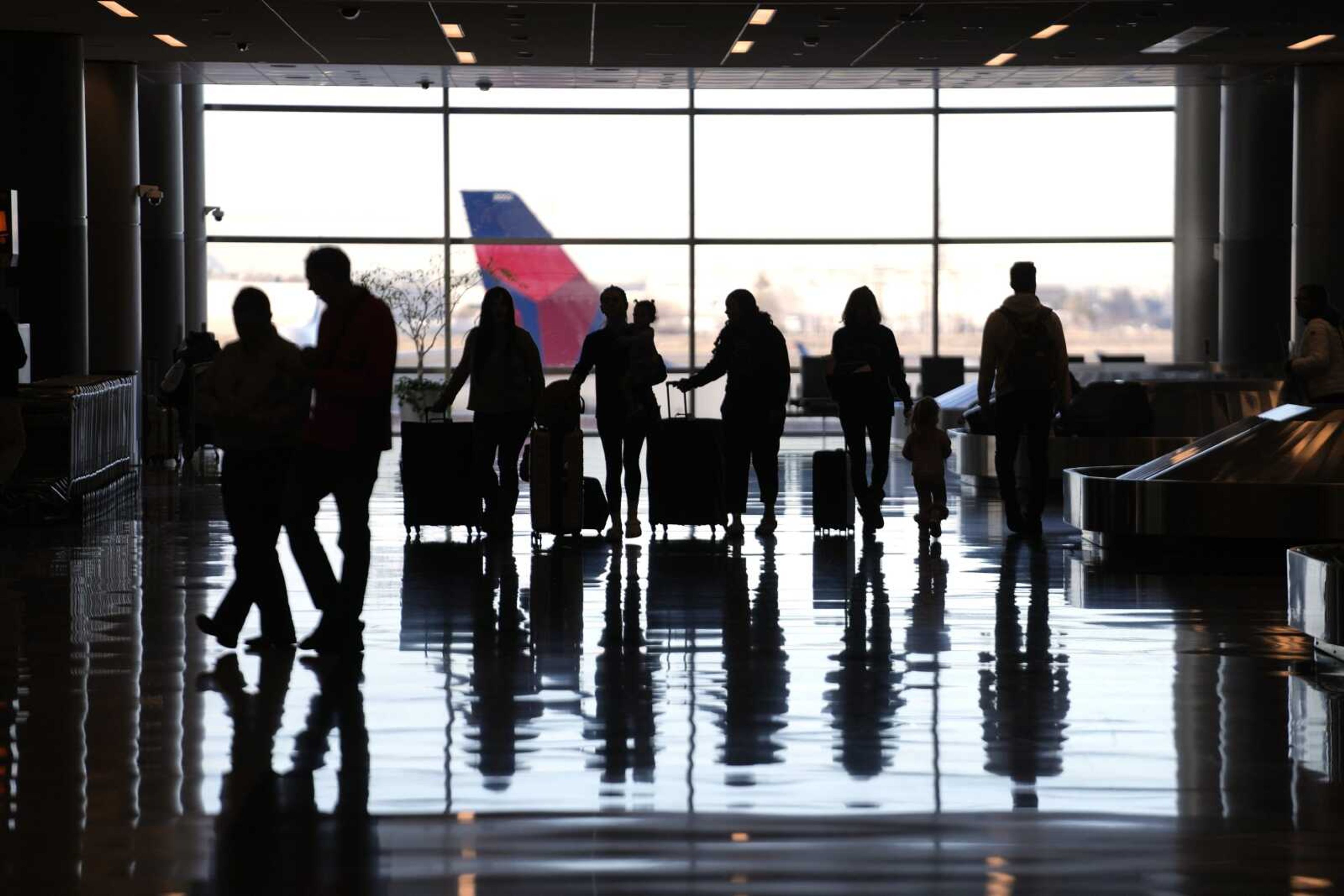 People pass through Salt Lake City International Airport Wednesday, Jan. 11, 2023, in Salt Lake City. The world's largest aircraft fleet was grounded for hours by a cascading outage in a government system that delayed or canceled thousands of flights across the U.S. (AP Photo/Rick Bowmer)