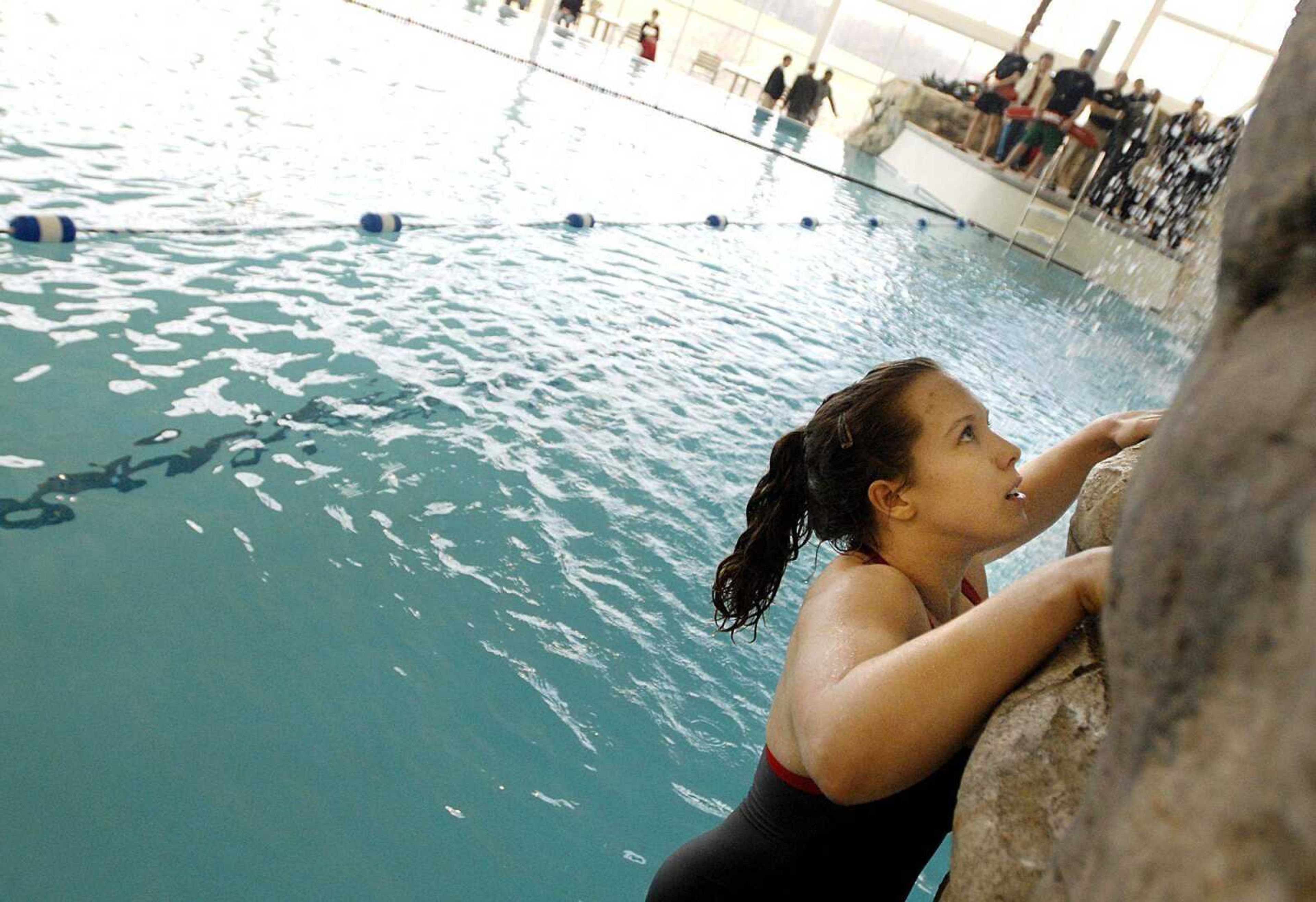 Kelley Krengiel, a sophomore at Southeast Missouri State University, was one of the first into the leisure pool, climbing the 40-foot bouldering wall at its edge after the ribbon-cutting ceremony Friday at the Student Aquatic Center. (Aaron Eisenhauer)