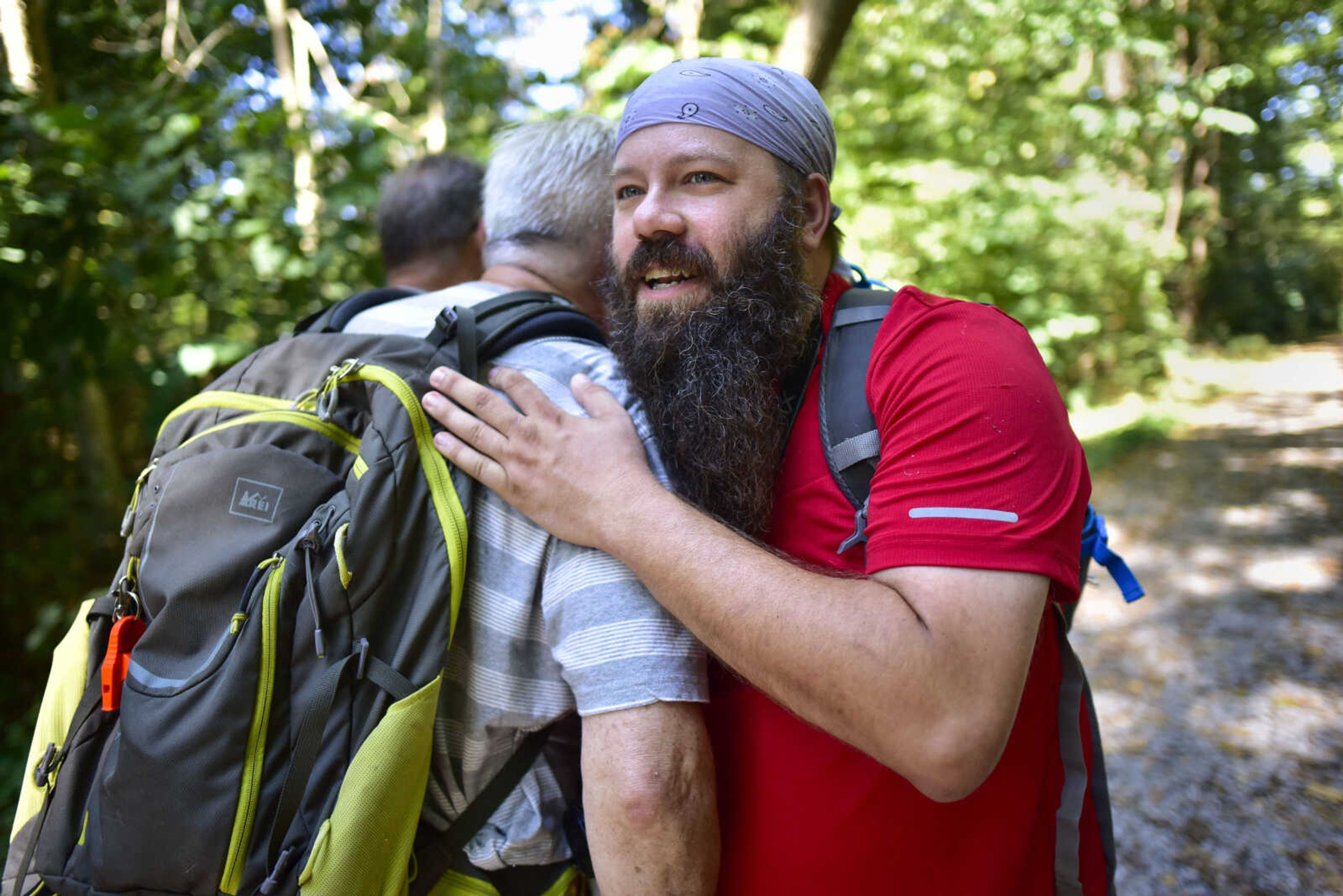 Jeremy Schumacher of Carbondale, Illinois, hugs Peter Berg of Chicago after accidentally crossing paths Saturday, Oct. 5, 2019, at Snake Road in Wolf Lake, Illinois.