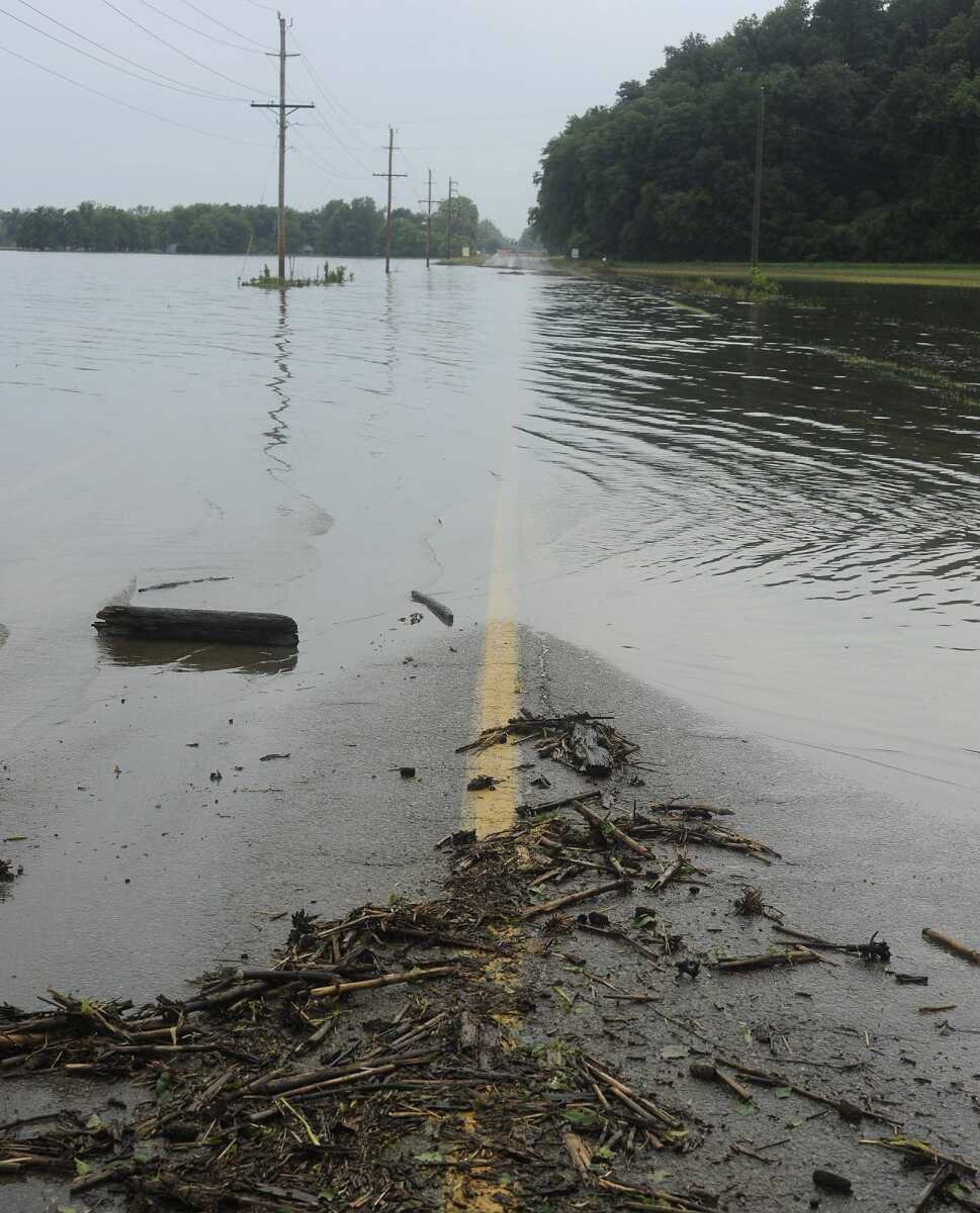 Flood debris and water covers Highway 74 near its intersection with Highway 25 Sunday, June 9, near Dutchtown. (Adam Vogler)