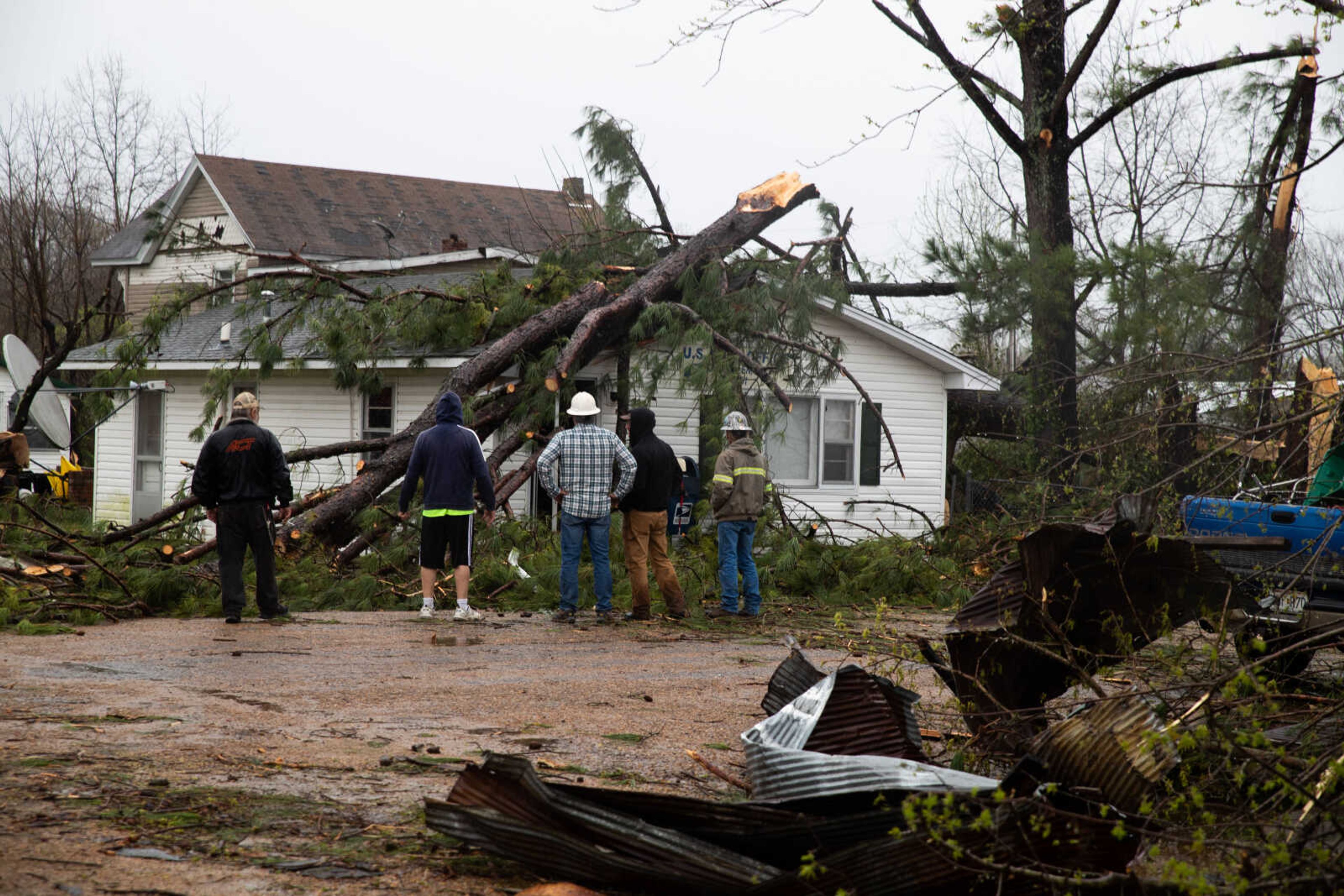 Community members decide how to remove a tree from the roof of the Glen Allen Post Office.