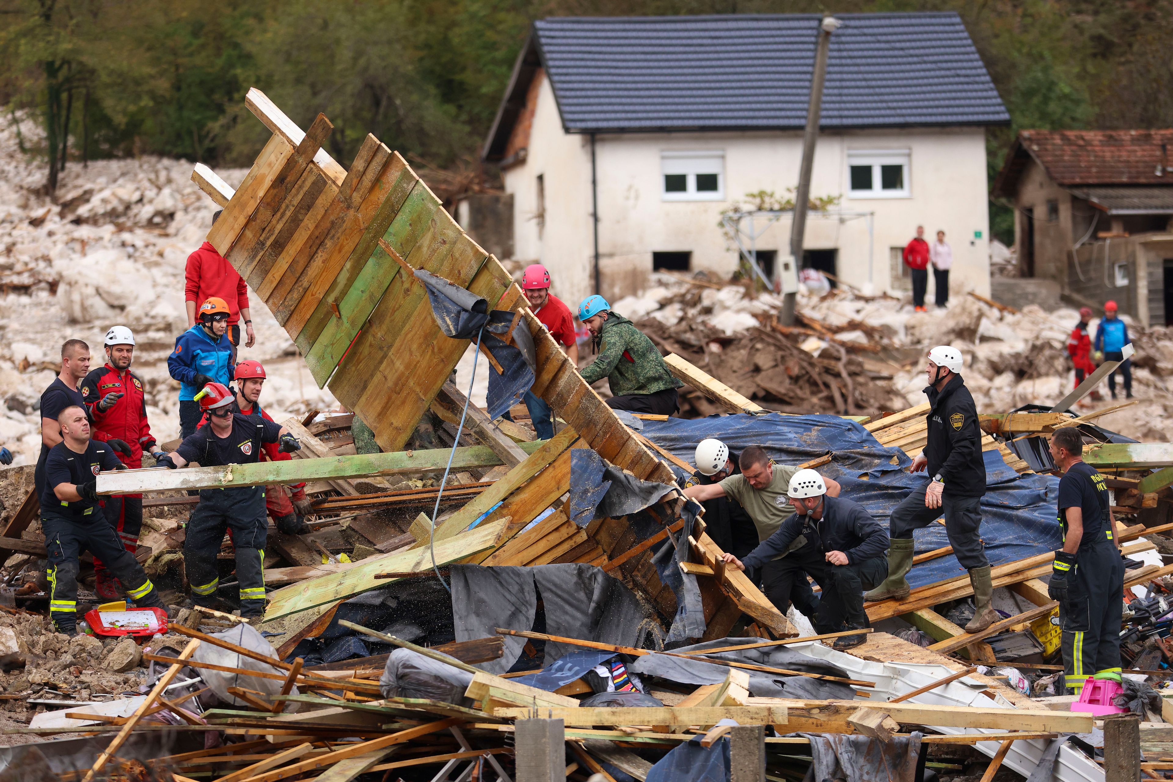 Rescuers search for missing people after floods and landslides in the village of Donja Jablanica, Bosnia, Saturday, Oct. 5, 2024. (AP Photo/Armin Durgut)